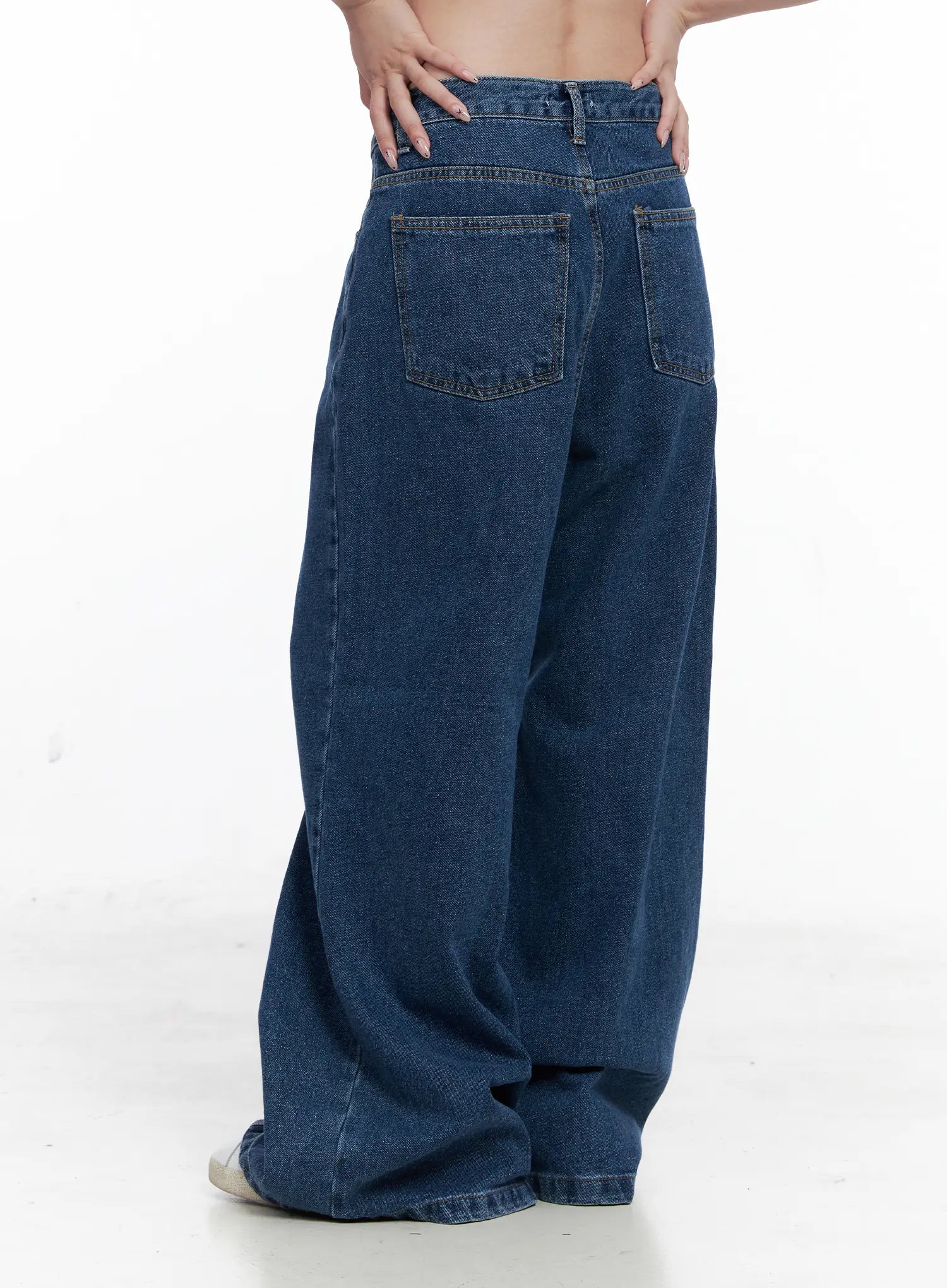 Eliza Seam Detail Relaxed Bootcut Jeans CO521 in washed blue, rear three-quarter view waist-to-floor on model, dual back patch pockets with topstitching, relaxed loose cotton denim.