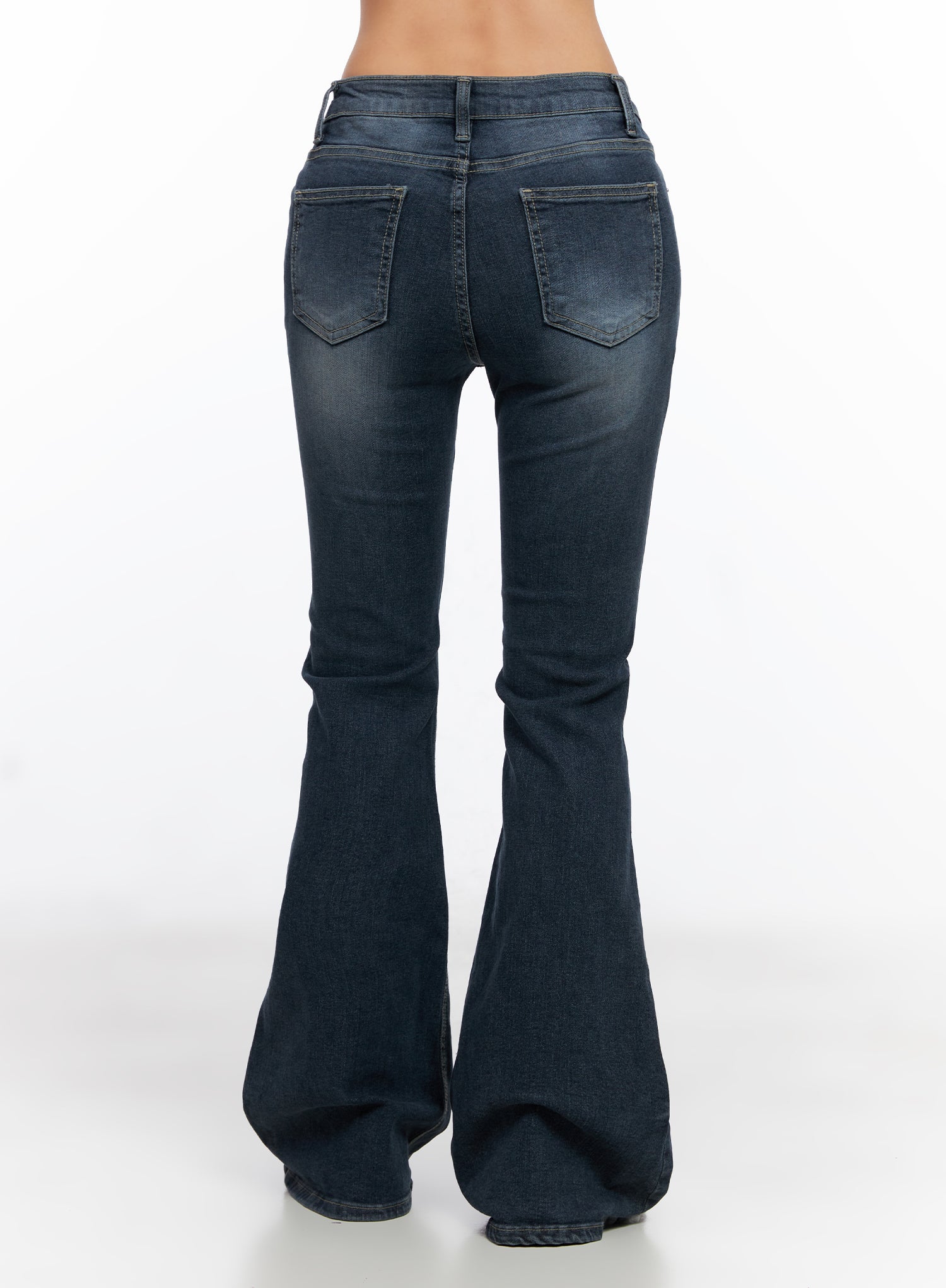 Melina Hip-Pad Low-Rise Flare Jeans CO514 in dark blue, back product shot cropped at waist, showing dual back patch pockets, washed denim finish, and dramatic bell flare hem.