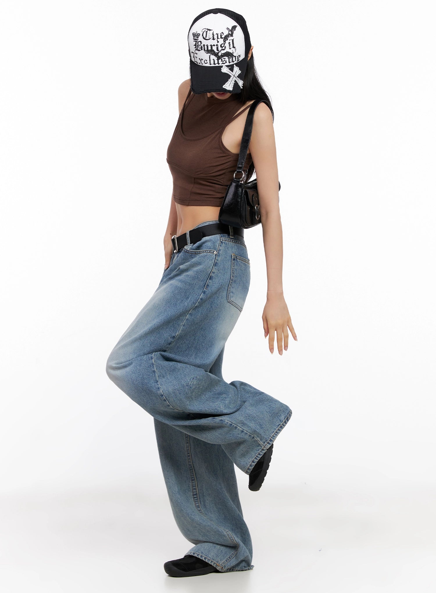 Seojin Washed Wide-Leg Jeans IG508 in blue, side-angle full-body on model in brown crop top, graphic trucker cap, and black bag, wide-leg silhouette in motion.
