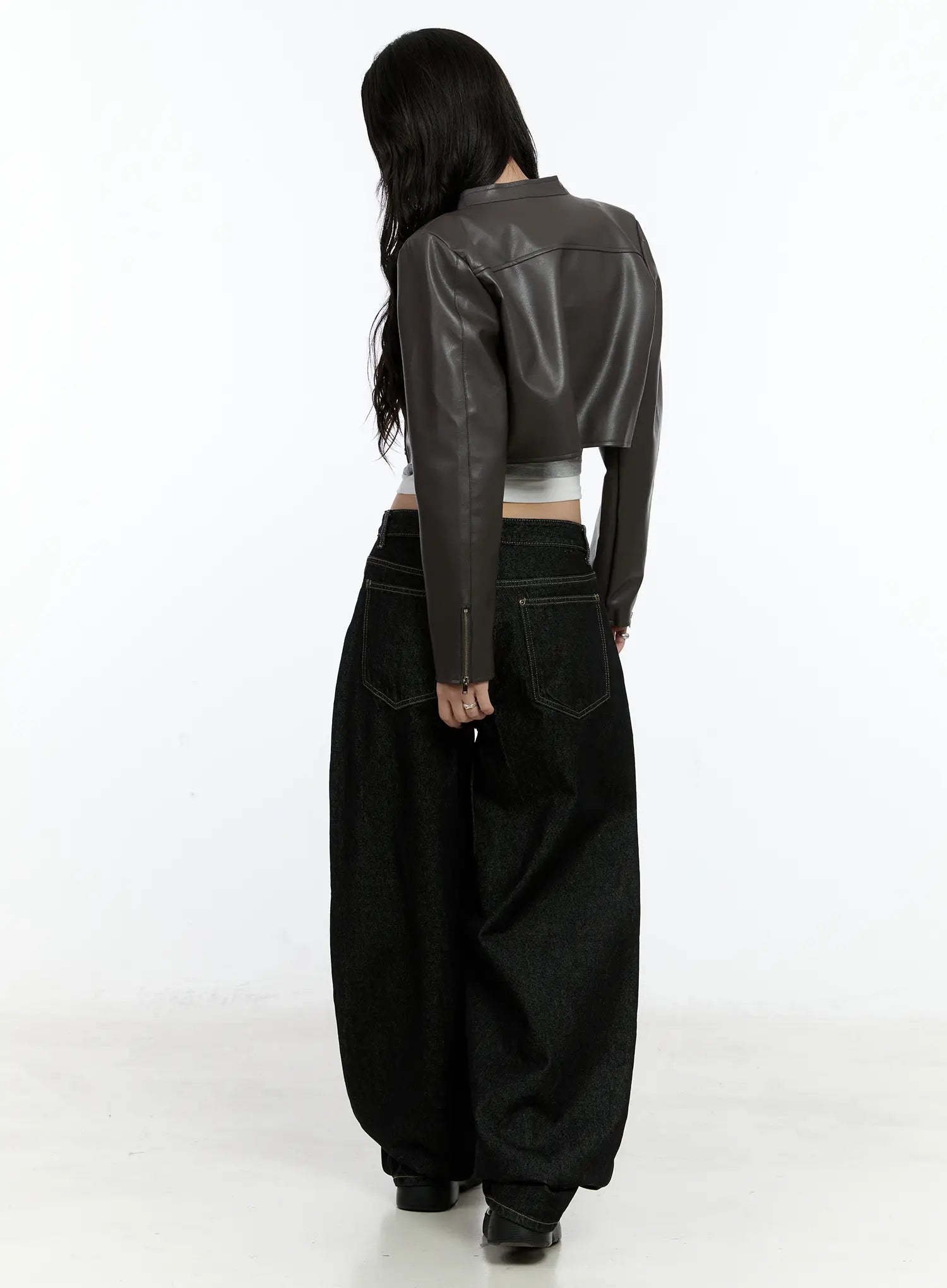 Maryam Low-Rise Dark-Washed Jeans CN517 in black, back view on model styled with brown cropped leather jacket, back pockets with contrast stitch, voluminous wide-leg denim.