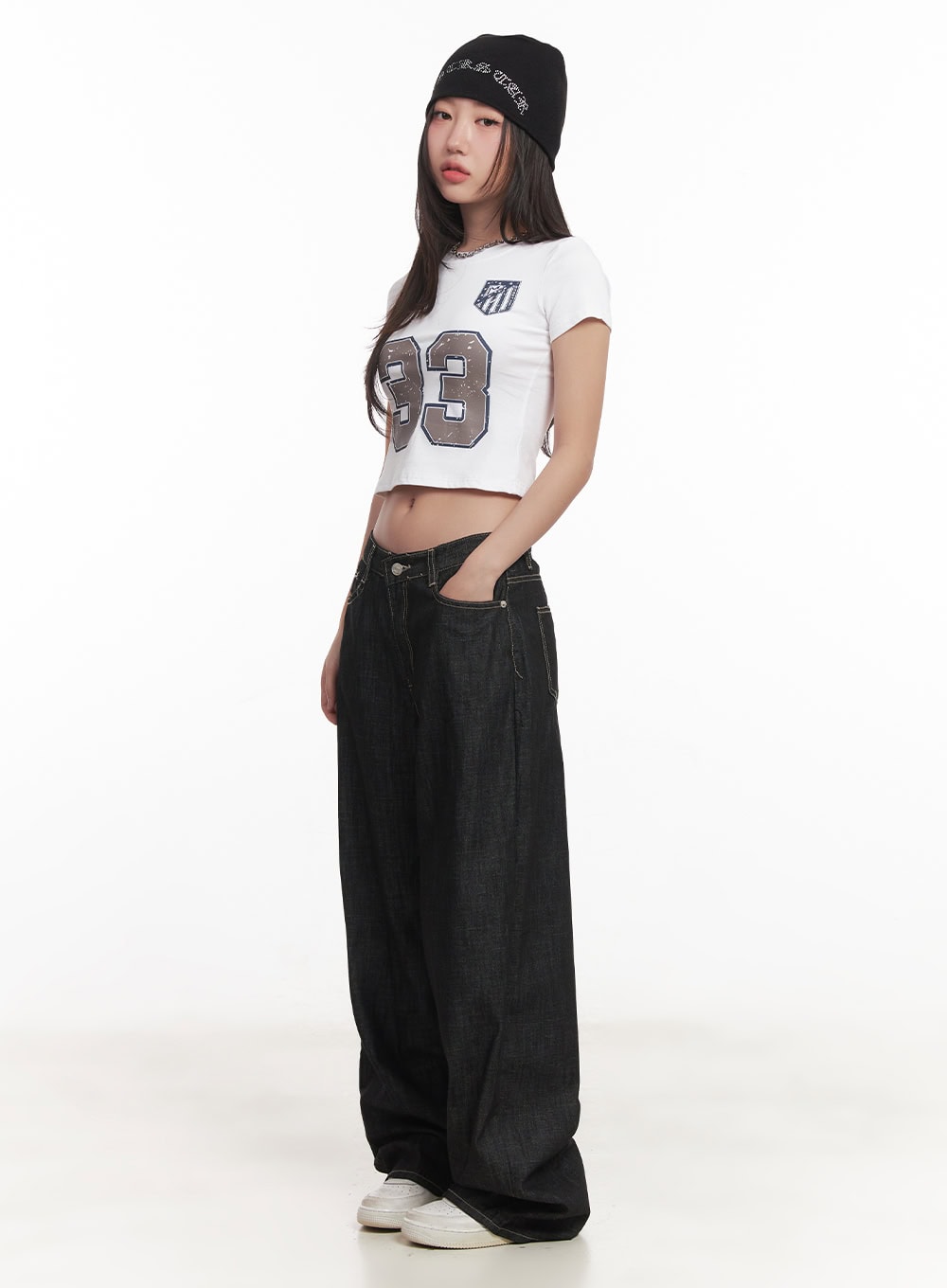 Fenna Baggy Jeans CA529 in black, side full-body on model with beanie and white crop tee, acubi street style, hand in pocket, wide-leg pooling at sneakers.