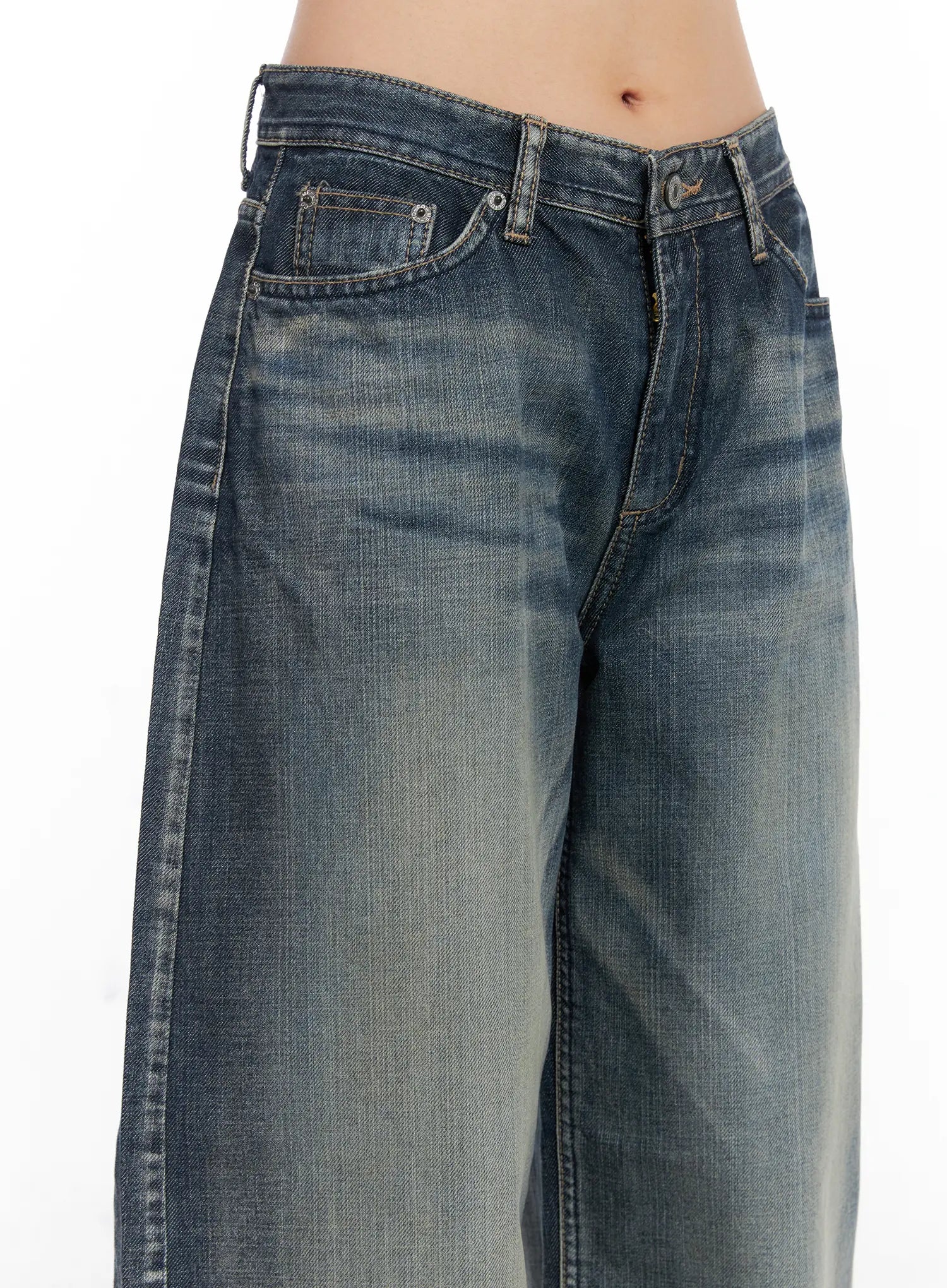 Nellie Baggy Jeans CS526 in blue, waist detail close-up on model, showing low-rise cut, coin pocket, button fly, and washed fading across the hip and thigh area.