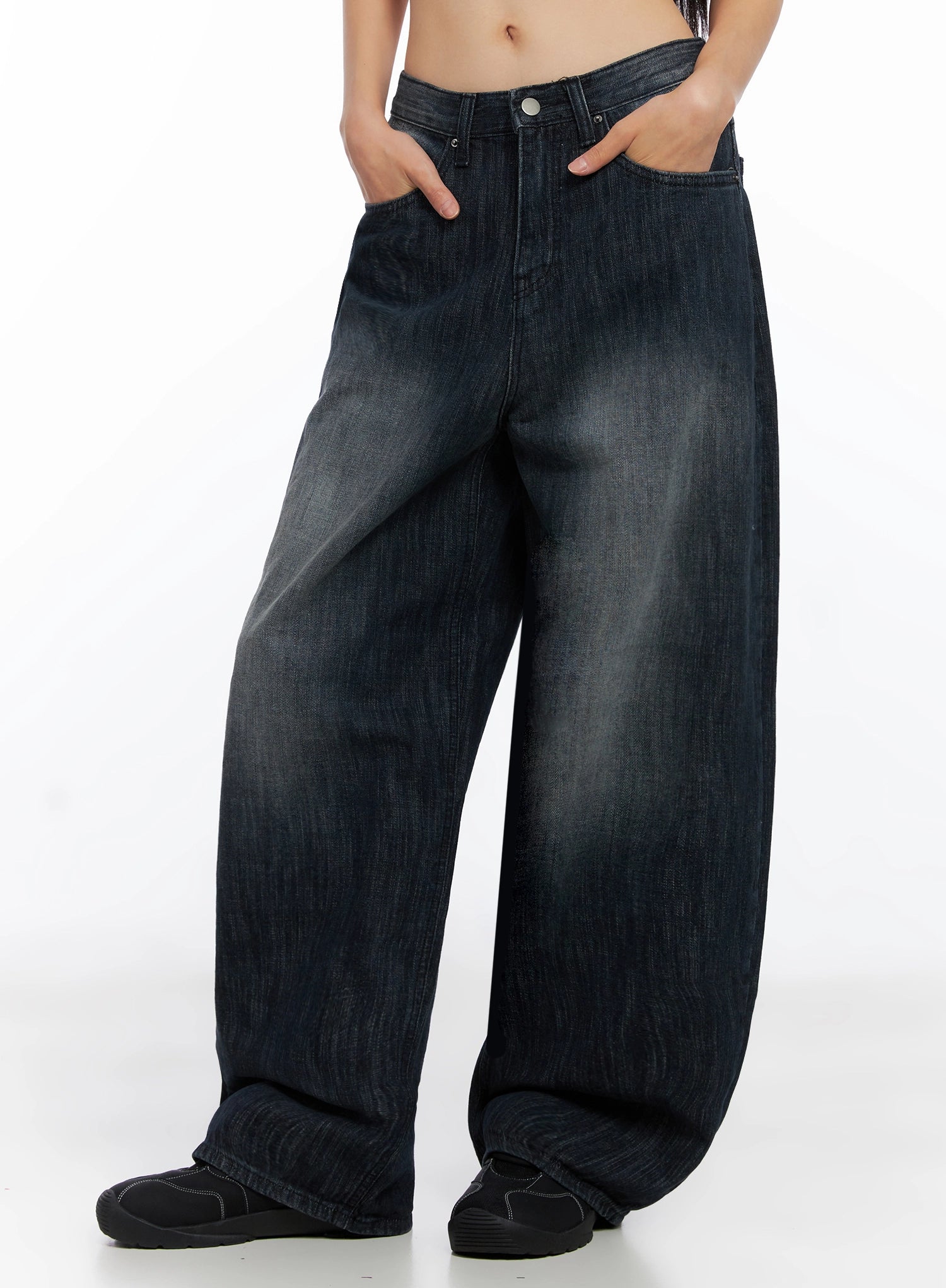 Minnell Vintage-Wash Wide-Leg Jeans IO517 in dark blue, angled front three-quarter view on model, hands in pockets, baggy wide-leg cotton denim with faded vintage wash detailing.