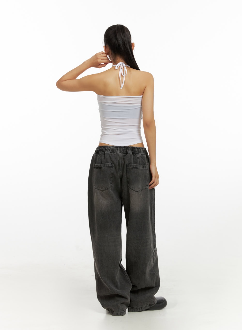 Banding Baggy Jeans IU412 in washed black, full back view on model, back patch pockets and elastic banded waist with drawstring detail, wide baggy washed denim, styled with white halter top.