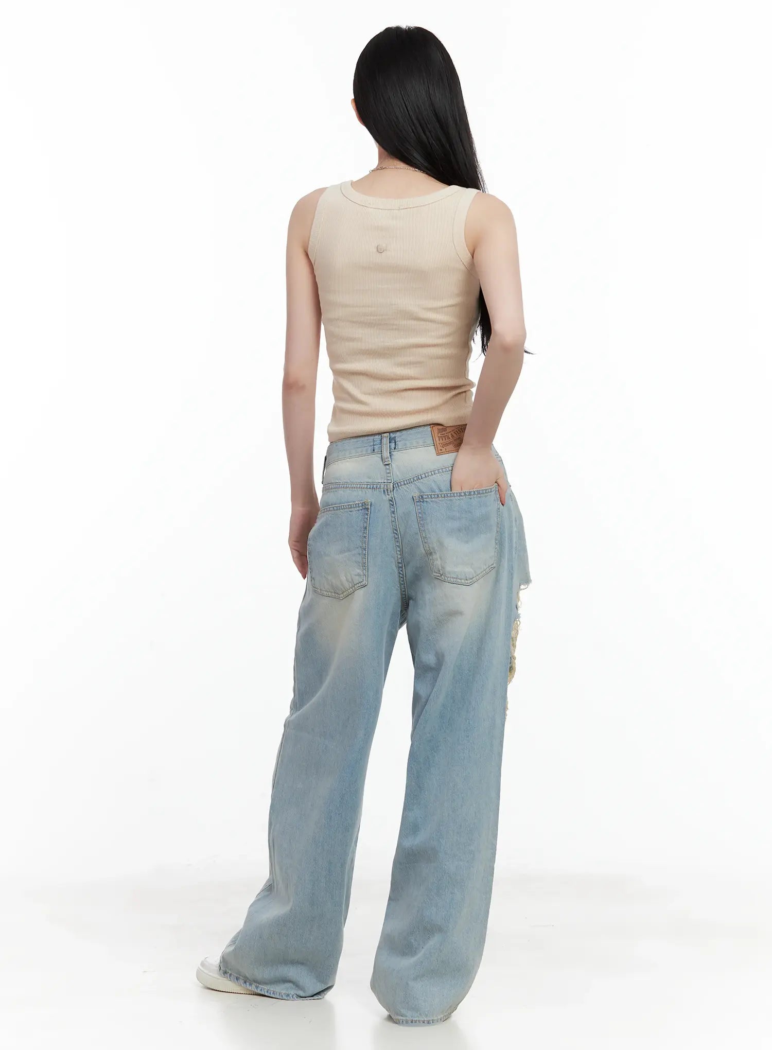 Gyuri Dirty-Wash Distressed Wide Jeans CU530 in blue, back view on model styled with beige ribbed crop tank, back pockets and leather logo patch visible, wide-leg fit.