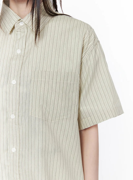 Oversized Short Sleeve Button-Up Shirt CU519 in light beige, close-up detail shot showing chest patch pocket, white button placket, and fine vertical stripe woven texture on boxy body.