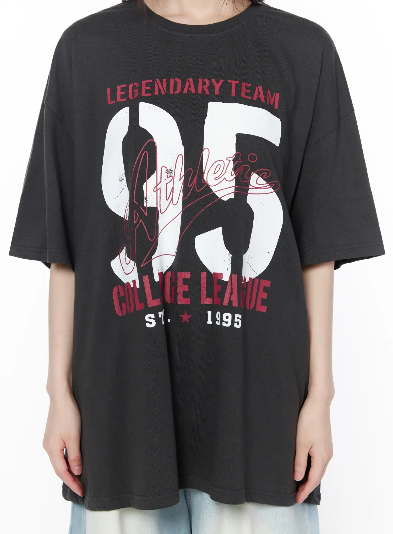 Oversized Graphic Tee CU519 in dark gray, graphic close-up on model torso, showing Legendary Team 95 Athletic College League distressed print detail with red and white lettering on crew neck tee.