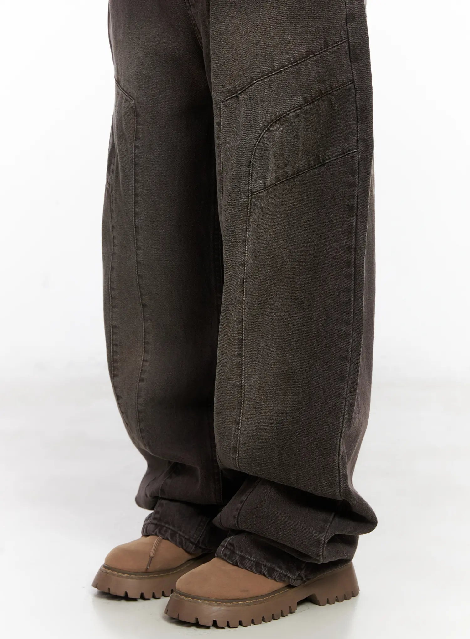 Elia Washed Baggy Jeans CN528 in dark brown, lower-leg close-up, curved panel seams and faded washed texture visible, extra-wide leg hem stacking over chunky boots.