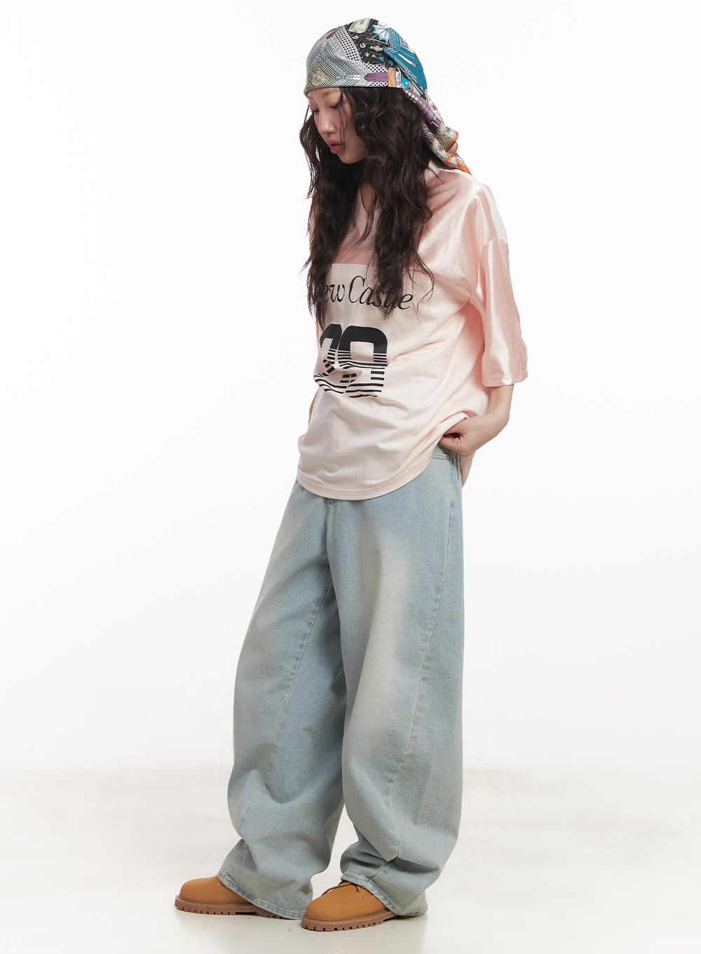 Alia Washed Wide-Leg Jeans CA518 in light blue, three-quarter front view on model looking down, wide-leg silhouette with faded wash, extra-wide hem stacking over boots, casual street styling.