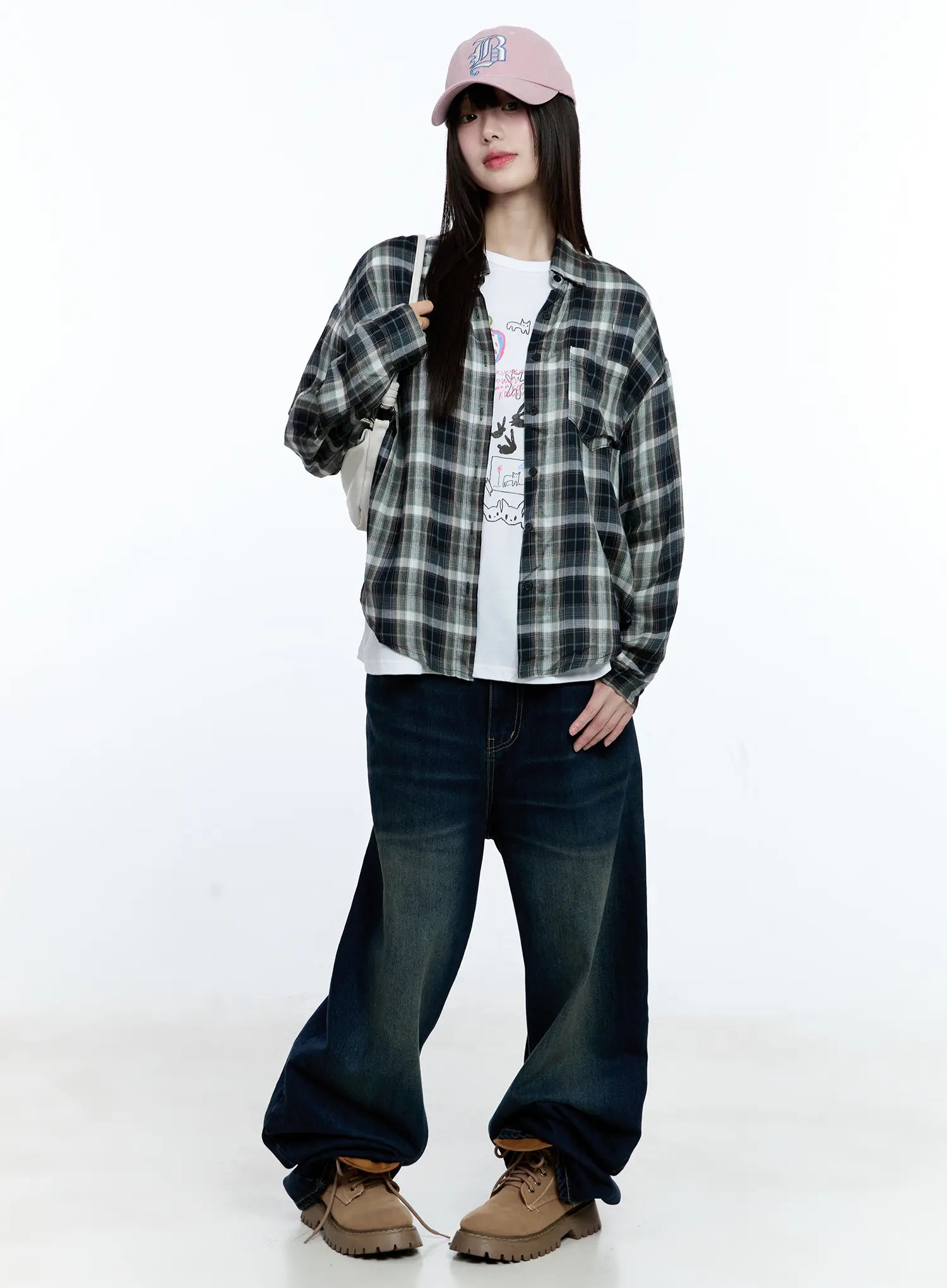 Jinnie Washed Wide-Leg Jeans CG511 in dark blue, full-body front editorial shot on model, layered with plaid overshirt, white graphic tee, pink cap and tote bag, casual street styling.