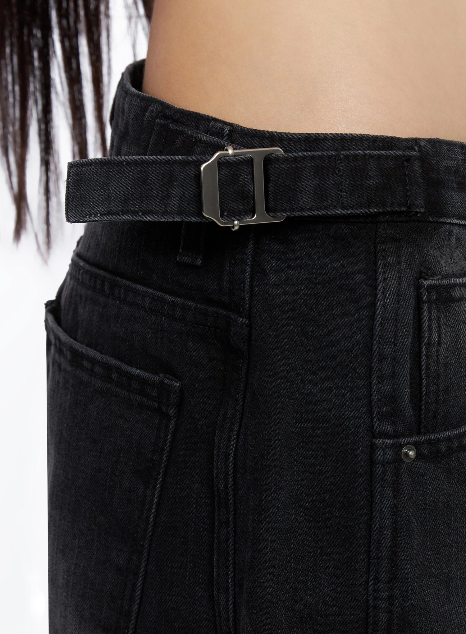 Goffel Side Belt Washed Wide Denim Pants IO517 in black, macro close-up of side belt buckle detail, silver-tone hardware on fabric belt strap, front pocket and denim weave visible.