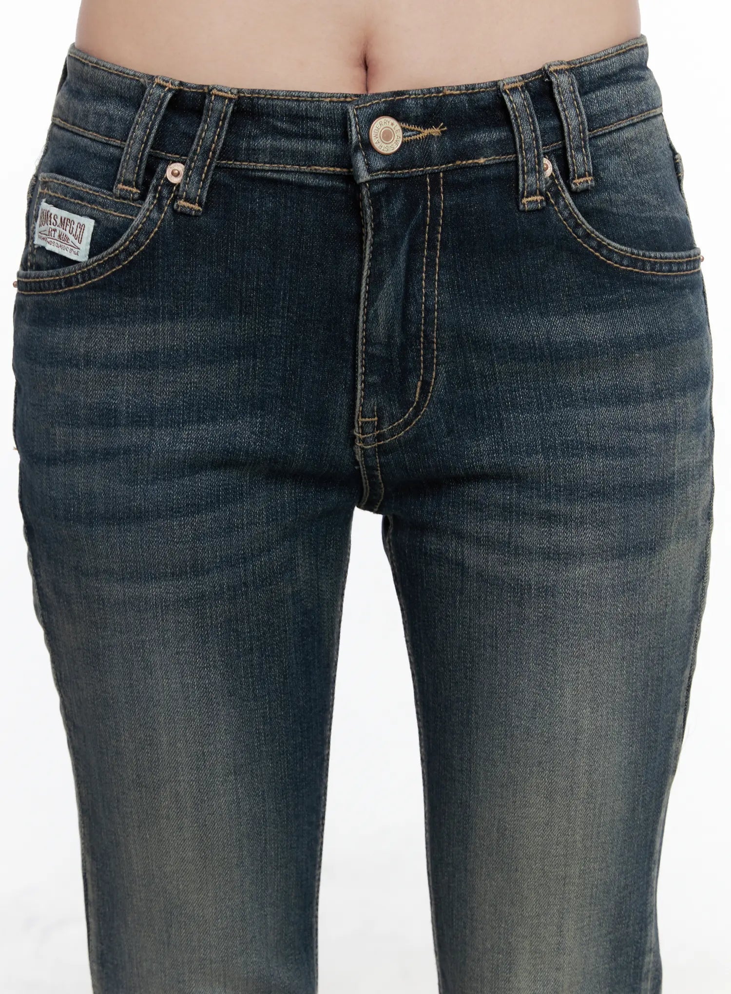 Rosé Washed Bootcut Jeans CO520 in dark blue, waistband close-up on model, gold button fly, front coin pocket with woven label patch, vintage whisker wash detail.
