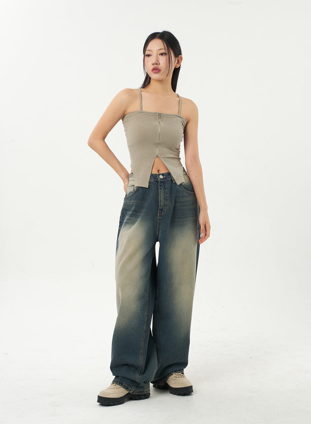 Mid-Rise Baggy Jeans CA325 in vintage blue denim, full-length front view on model with one hand on hip, relaxed wide-leg fit and gradient sun-fade, styled with beige ribbed cami top.
