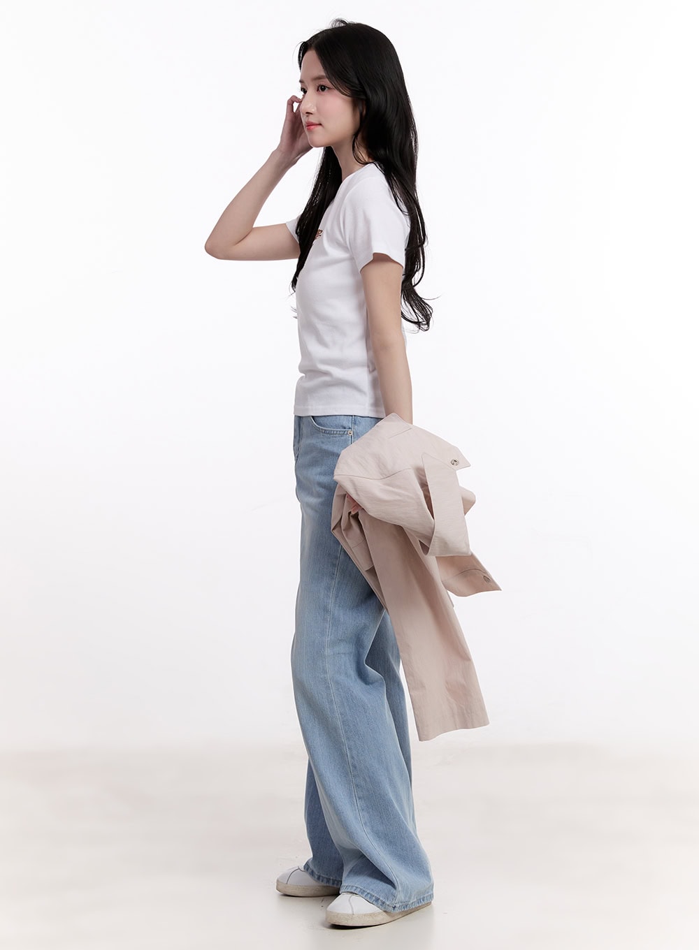 Daniella Relaxed-Fit Flared Jeans CM526 in light blue, side full-length shot on model, showing wide-leg flare profile and high waist, styled with white tee and beige jacket in hand.