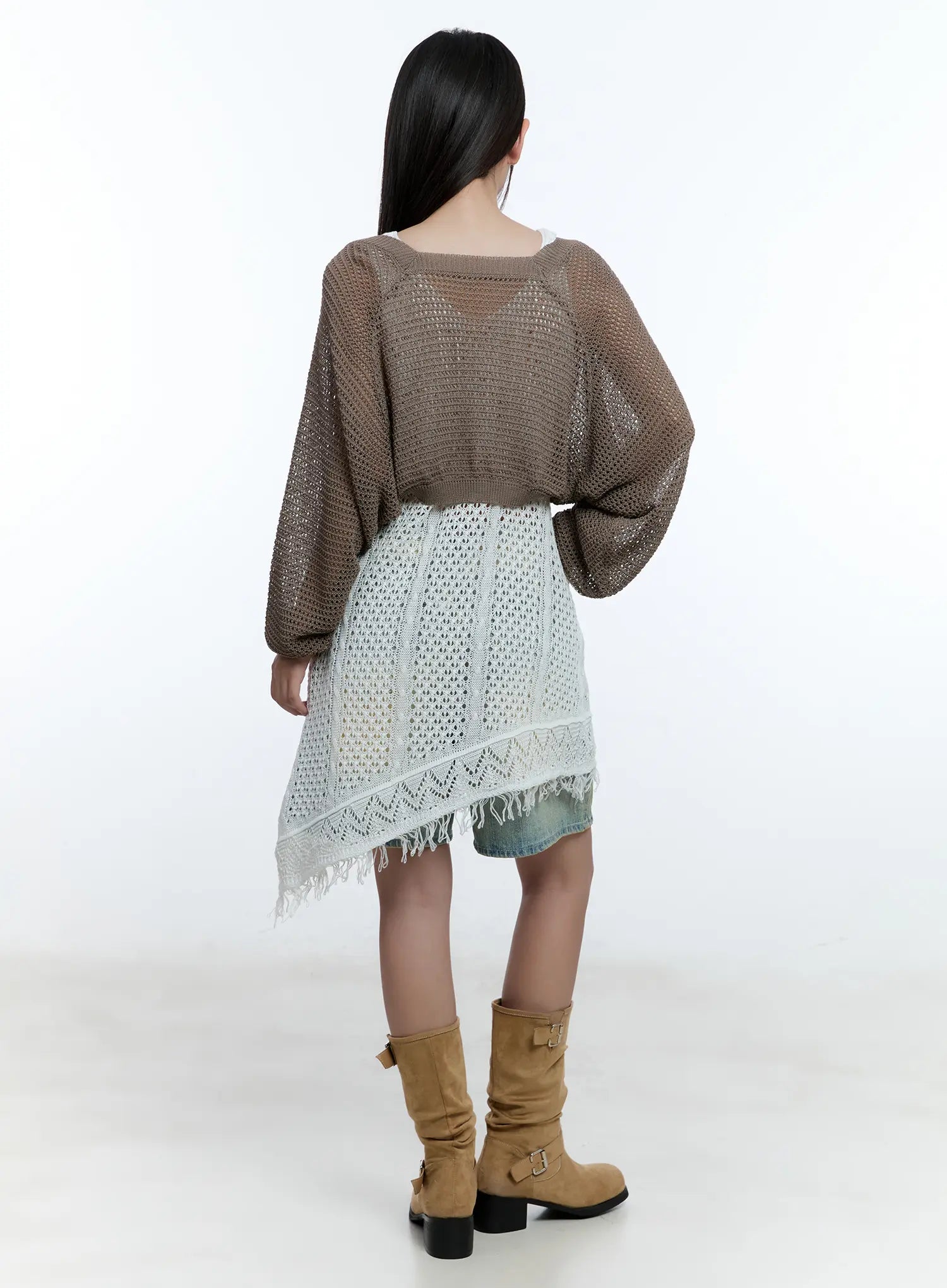 Vintage Wash Jorts CU527 in light blue, back full-body editorial shot on model, denim hem showing under asymmetric fringe crochet dress and open-knit cardigan, tan boots.