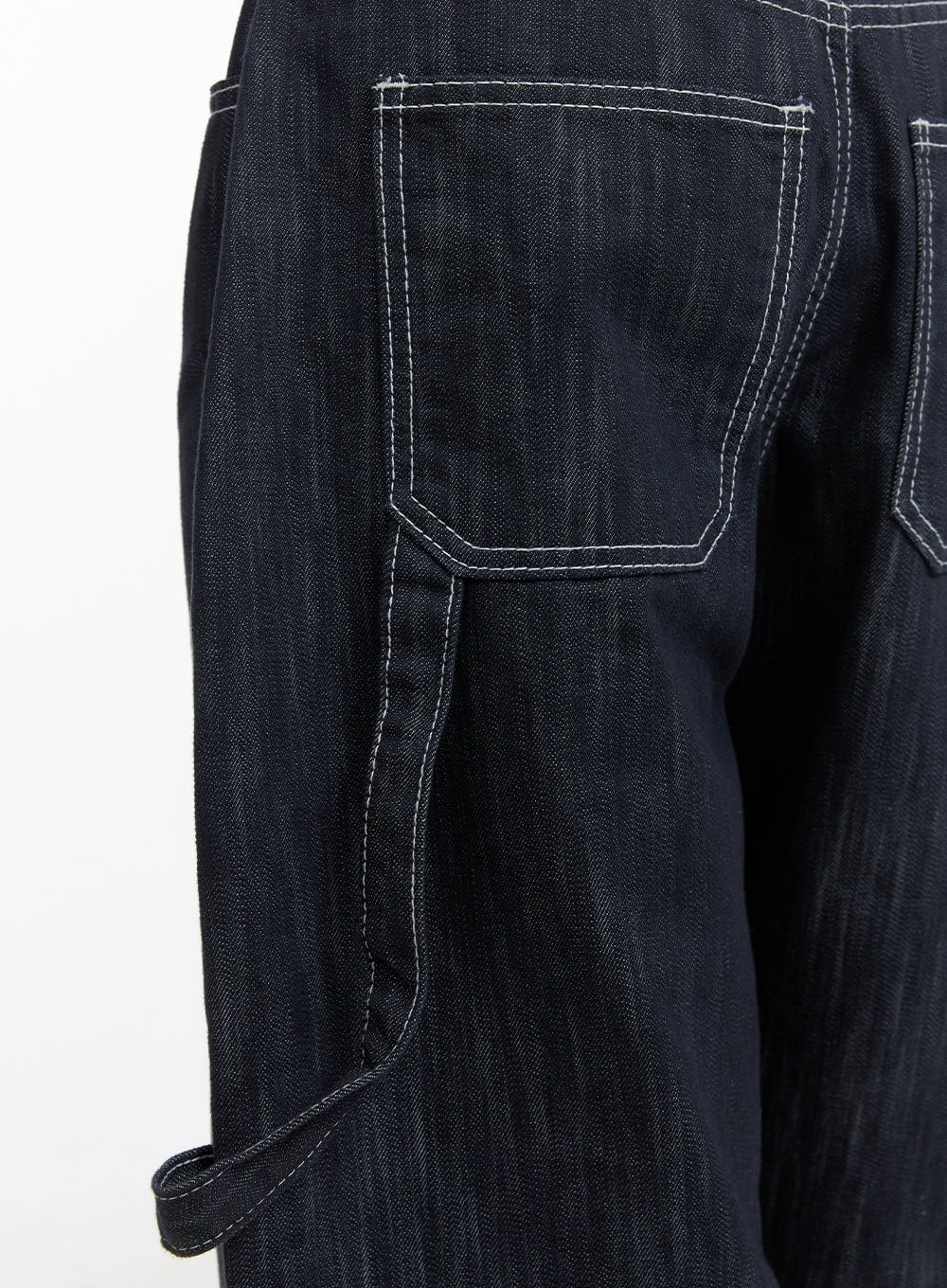Low-Rise Strap Baggy Jeans CY414 in dark blue, macro close-up of back patch pocket and carpenter strap with bold white contrast topstitching on dark cotton denim.