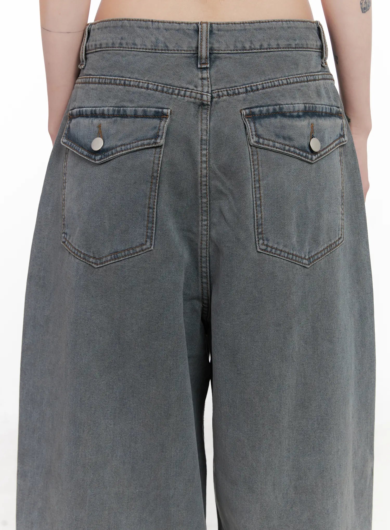 Odet Wide-Leg Balloon Jeans CN512 in blue, macro close-up of back pockets, detailing stitched pocket flaps, silver rivet buttons, and washed denim texture.
