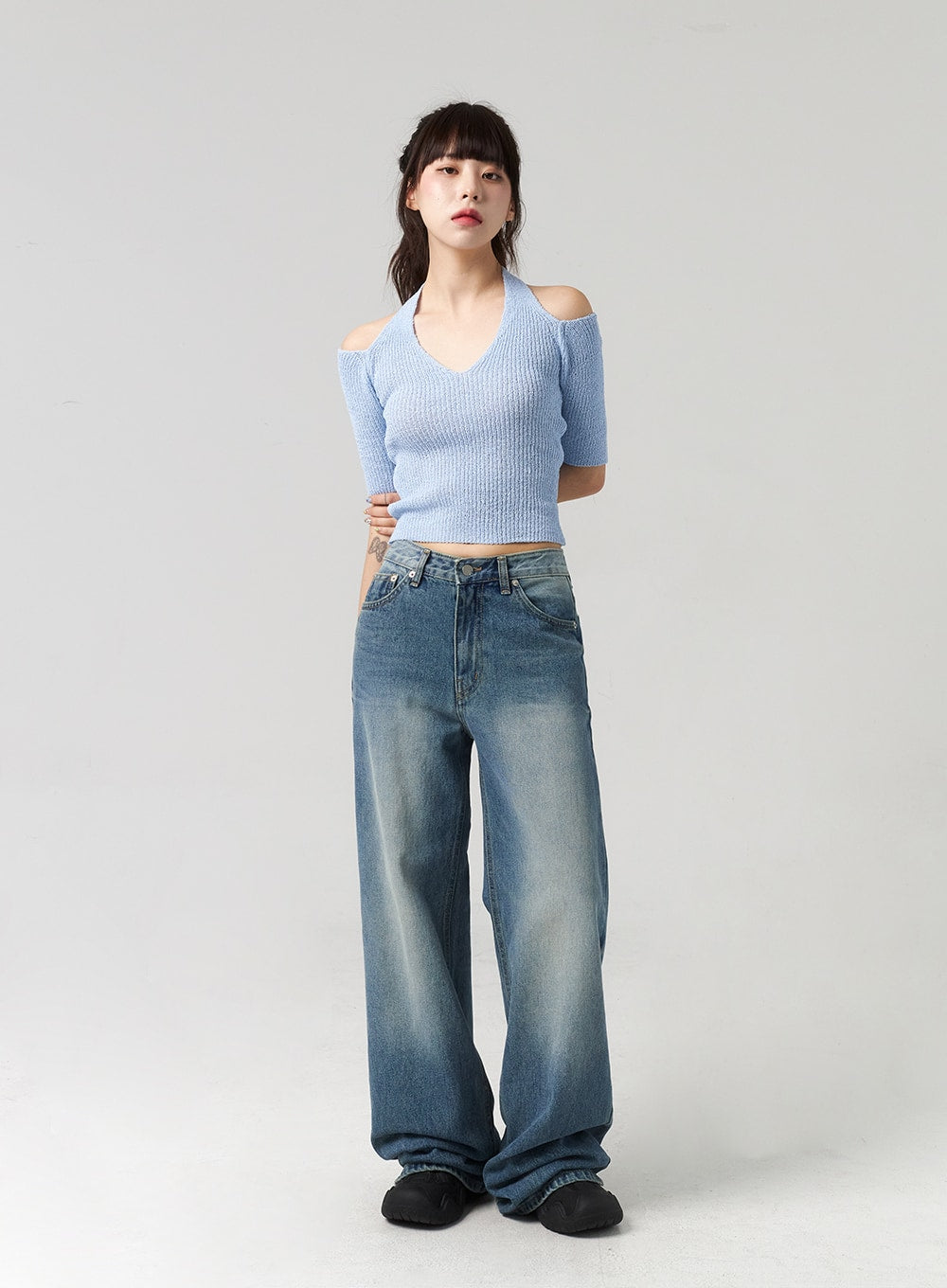 Mid-Wash Baggy Jeans CL312 in mid-wash blue, full-length front view on model, baggy wide-leg cotton denim with washed fading, styled with blue halter crop knit top.