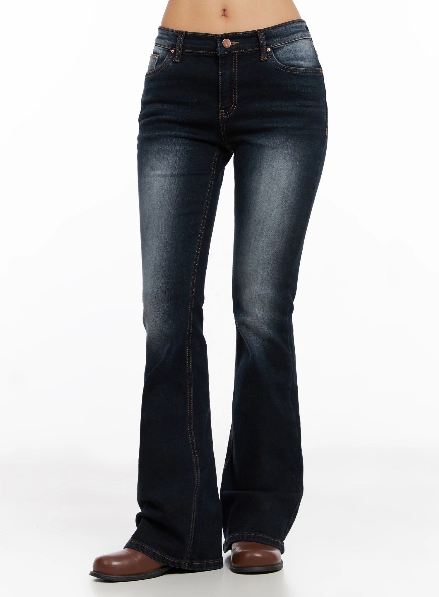 Aliyah Mid-Rise Hip Pad Flared Jeans IG528 in dark blue, front full-length model shot without top, deeper wash tone, flared bootcut hem with contrast topstitching, brown boots.