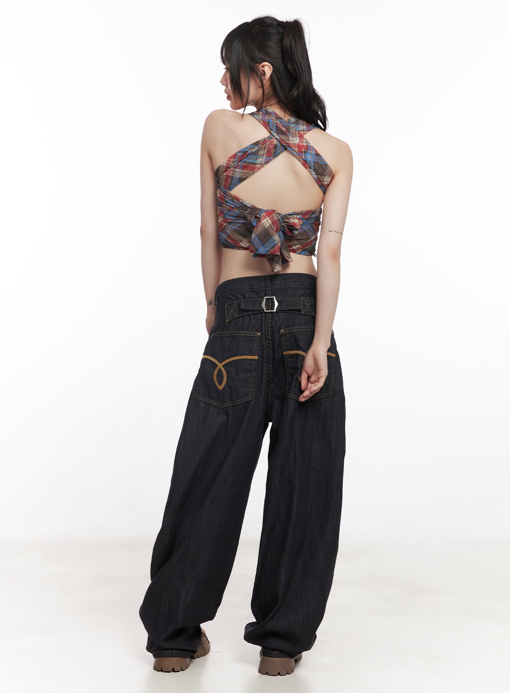 Jessie Stitched Wide-Leg Jeans CY520 in dark blue, back full-body view on model, silver buckle back waistband, golden embroidered pockets, baggy leg, paired with open-back plaid crop top.