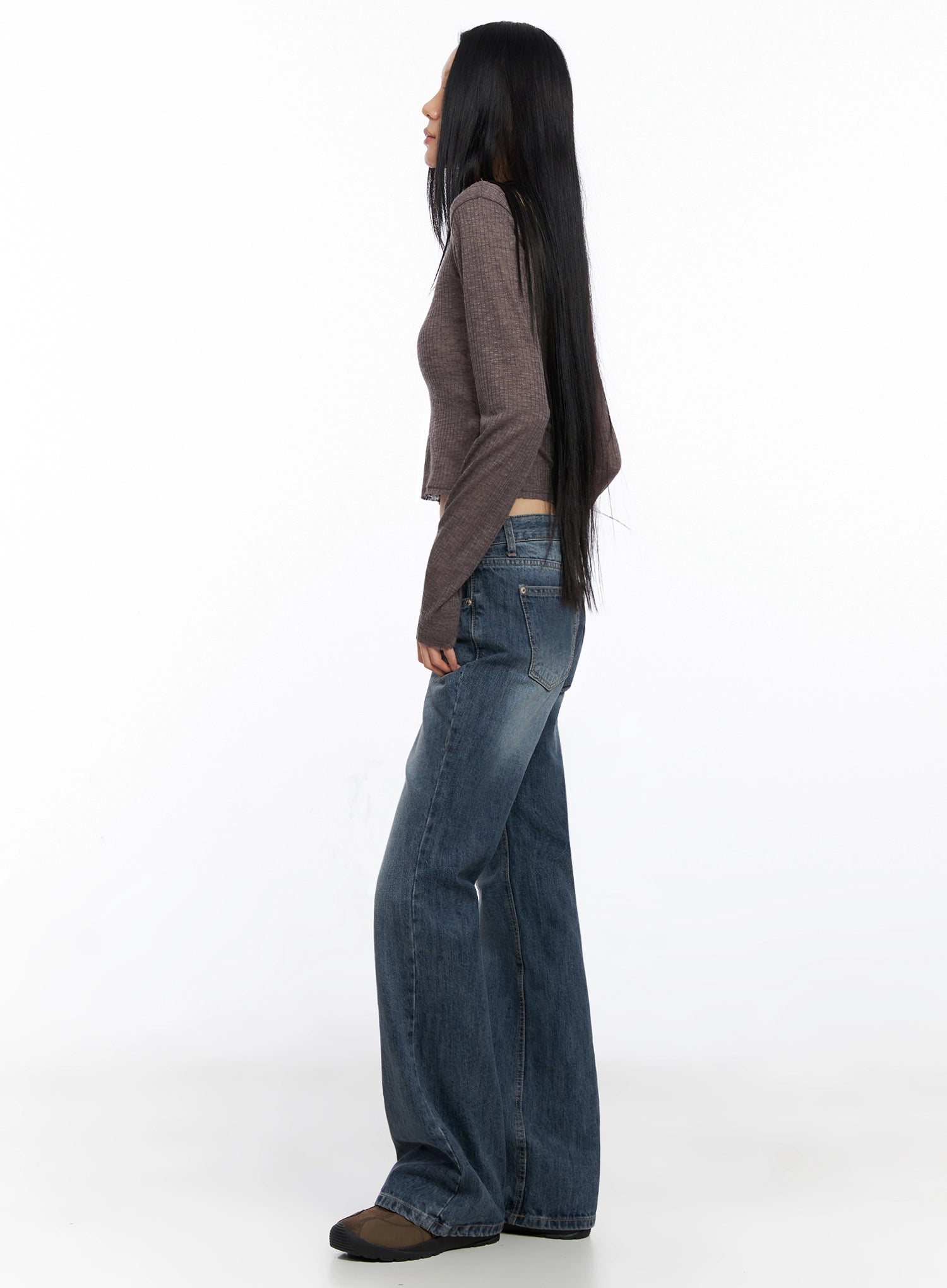 Myra Washed Bootcut Jeans IO516 in dark blue, side profile view on model, full-length shot showing elongated bootcut leg and low-rise waist, styled with brown knit crop top.