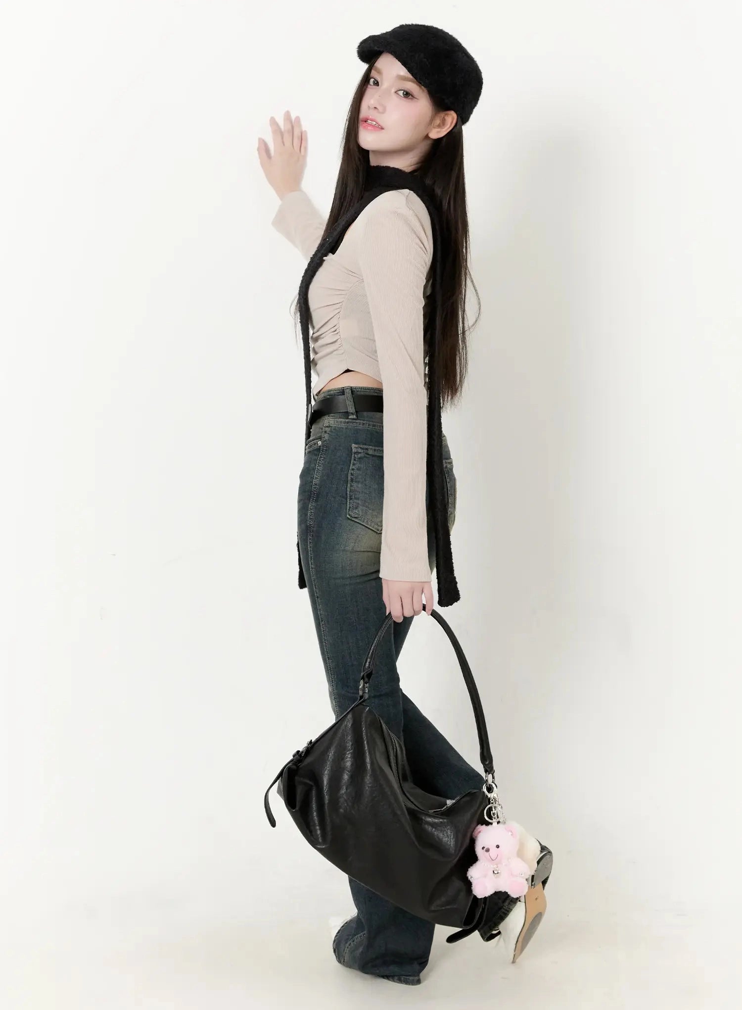 Karla Vintage Logo Hip Pad Flare Jeans IO520 in washed dark blue, side full-body on model, long flare silhouette, styled with beige top, black beret, and oversized leather bag.