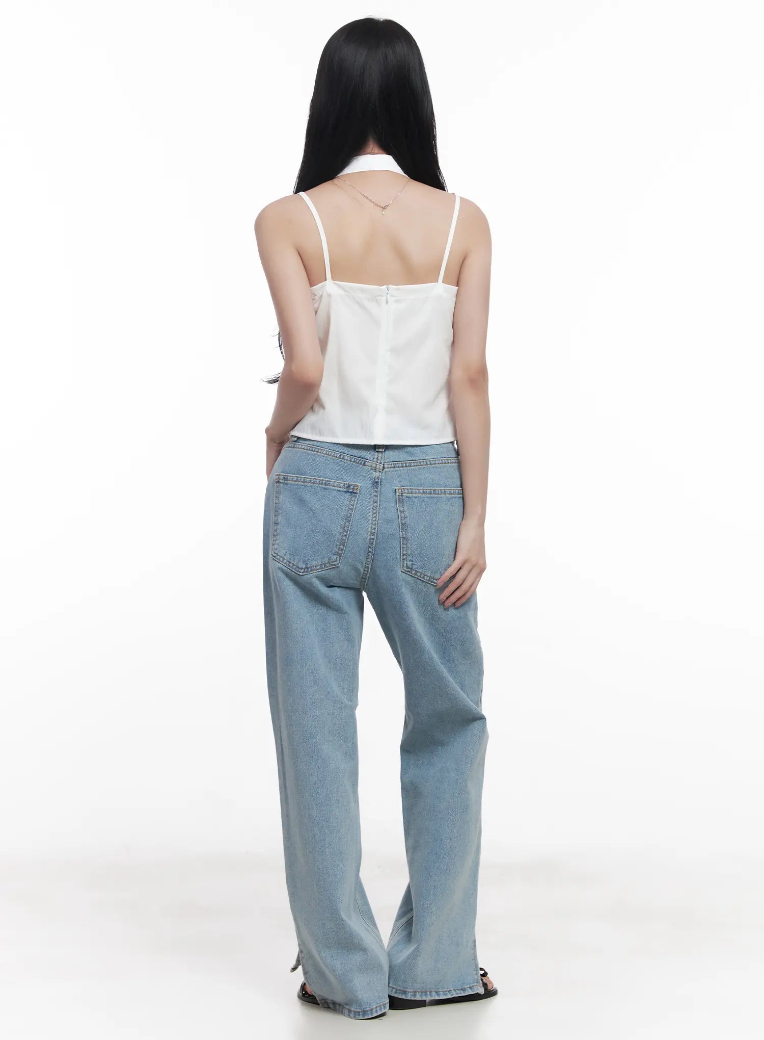 Hyuna Slit Straight-Fit Jeans CU525 in light blue, full back view on model, wide-fit washed denim with back pockets and visible hem slit at ankle, paired with white halter top.