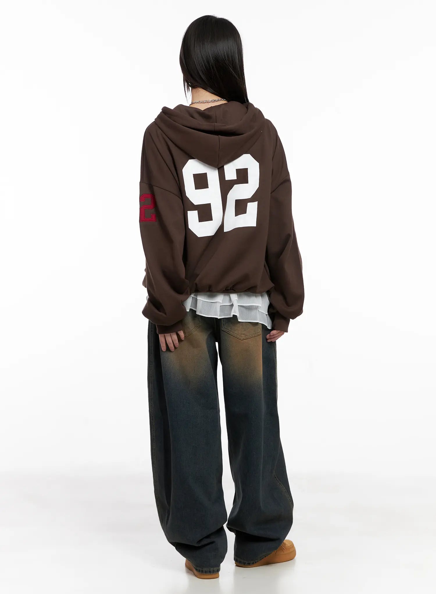 Jaycee Vintage Wash Baggy Jeans CG519 in dark blue, back editorial shot on model, styled with brown varsity hoodie, showing full-length wide baggy silhouette and vintage wash.