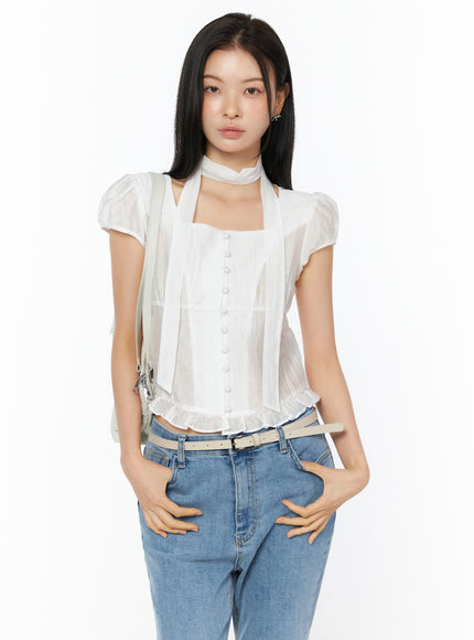 Puff Sleeve Shirred Blouse with Scarf IU519 in white, front view on model with crossbody bag strap, square neck button-front blouse with scarf and ruffled hem, styled with jeans and belt.