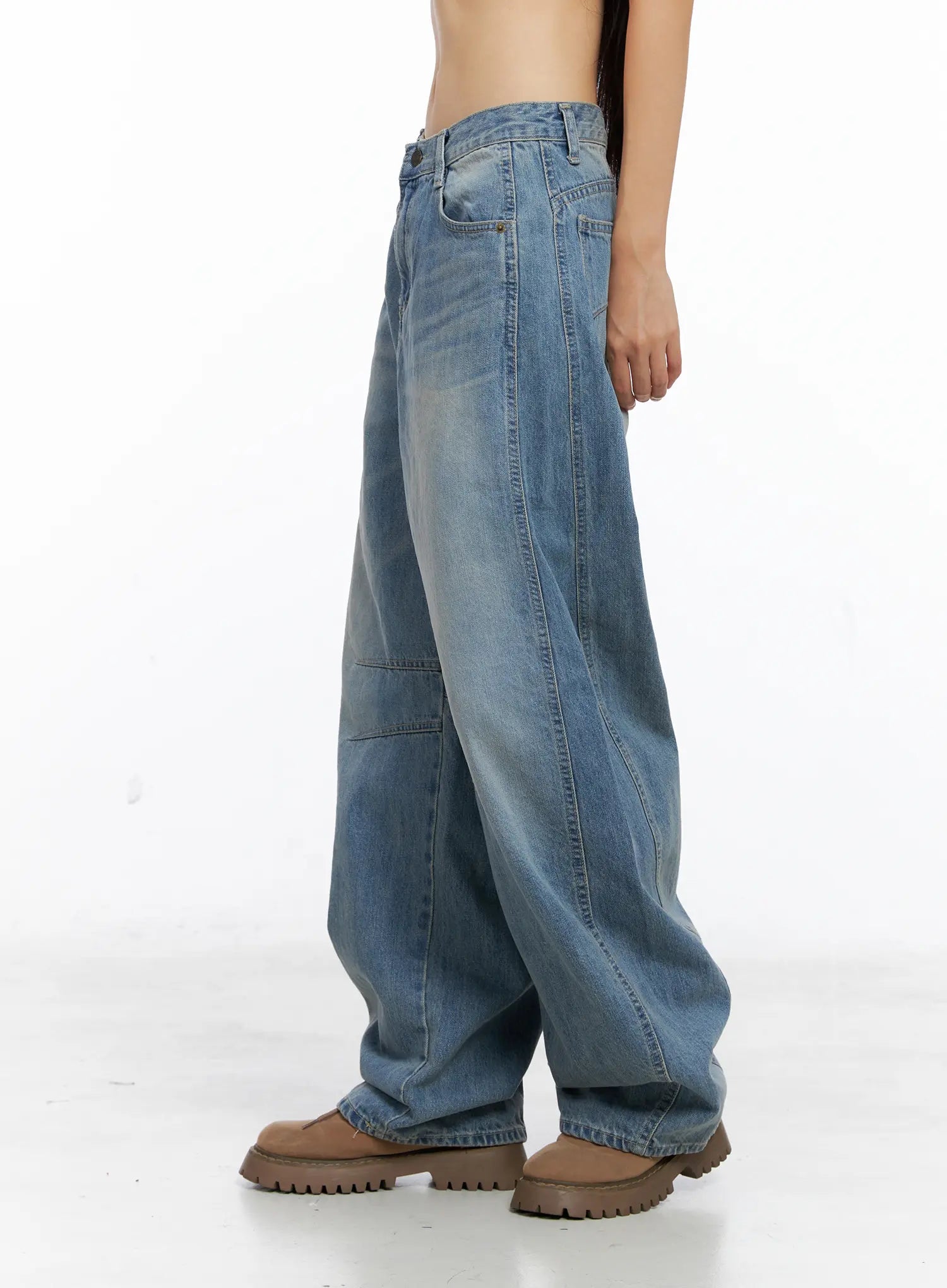 Dakota Relaxed Fit Vintage Wash Jeans CS511 in blue, side close-up studio shot from waist to hem, wide-leg cotton denim highlighting front seam panel, knee stitch detail, and washed texture, tan boots.