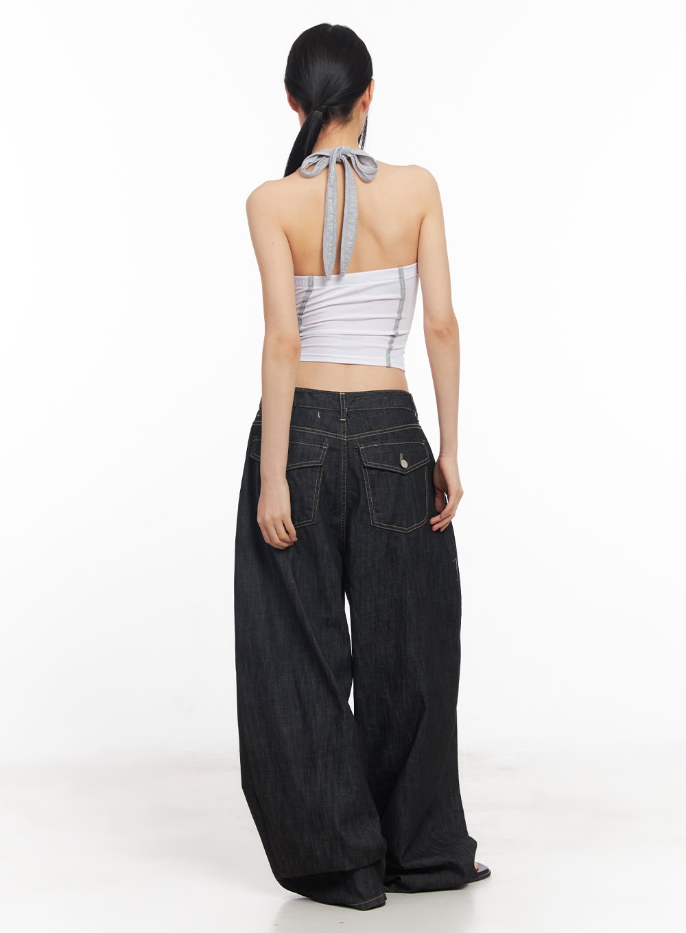 Elvie Baggy Jeans CY528 in black, back full-length shot on model, oversized denim with flap back pockets and contrast topstitching, styled with a halter crop top.