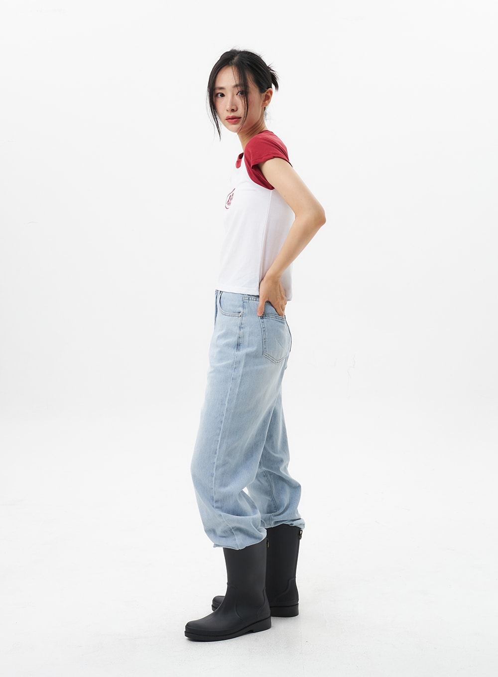 Wide Straight Leg Jeans OL304 in light blue, three-quarter side view on model, wide straight-leg denim with light wash, back pocket visible, hem bunching over rain boots.