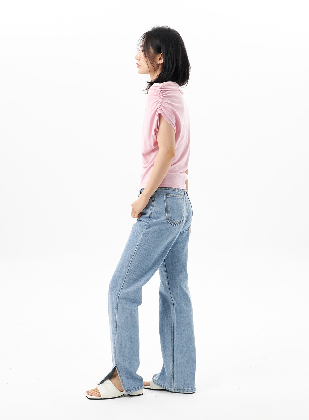 Slit Detail Jeans OU314 in blue, side profile full-length on model looking away, straight-leg cut with ankle slit, styled with pink top and white slide sandals.