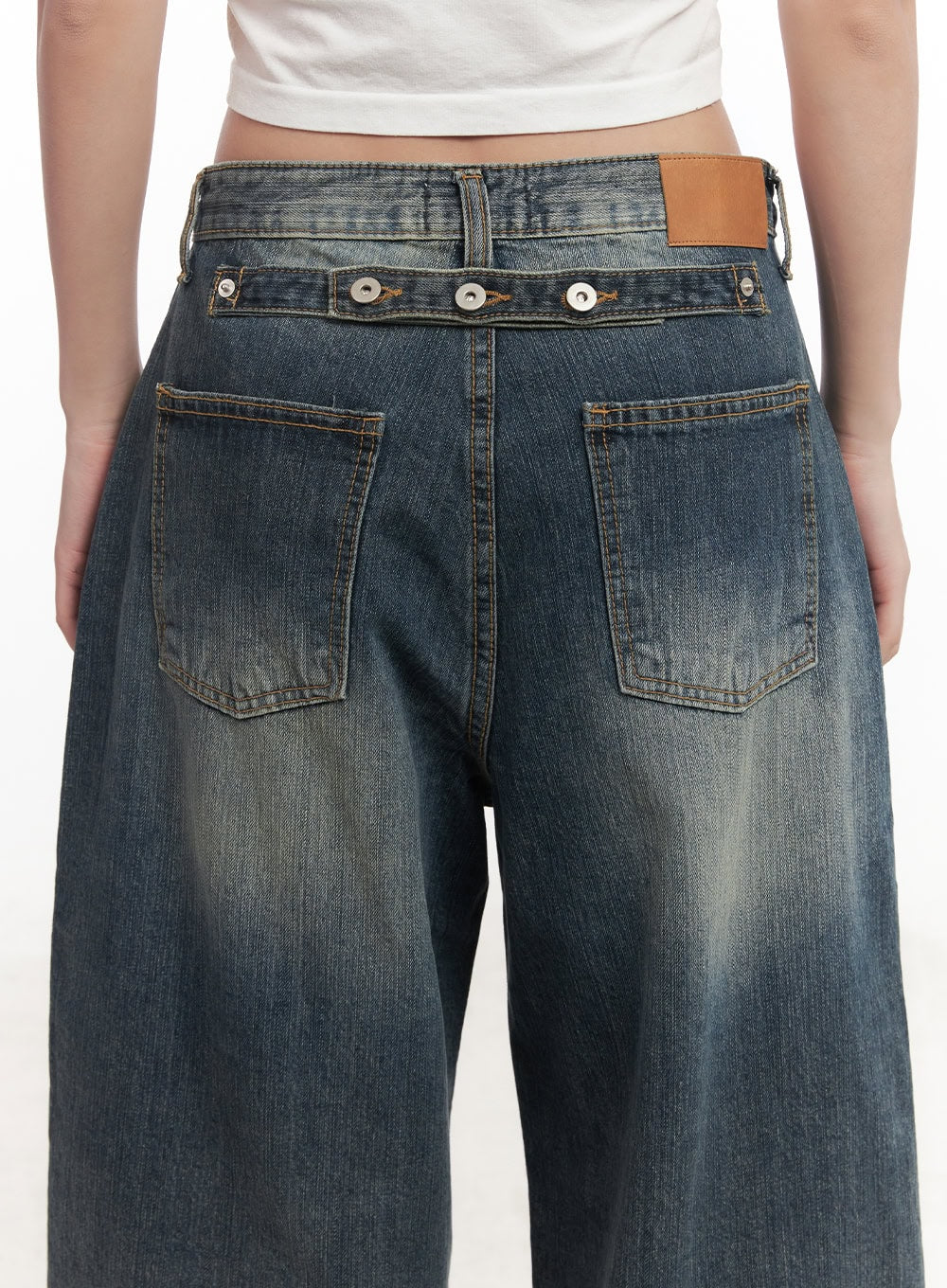 Leilani Washed Baggy Jeans CM531 in dark blue, back waist close-up on model, detail shot of snap-button waistband, dual patch pockets, tan leather tab, and vintage wash stitching.
