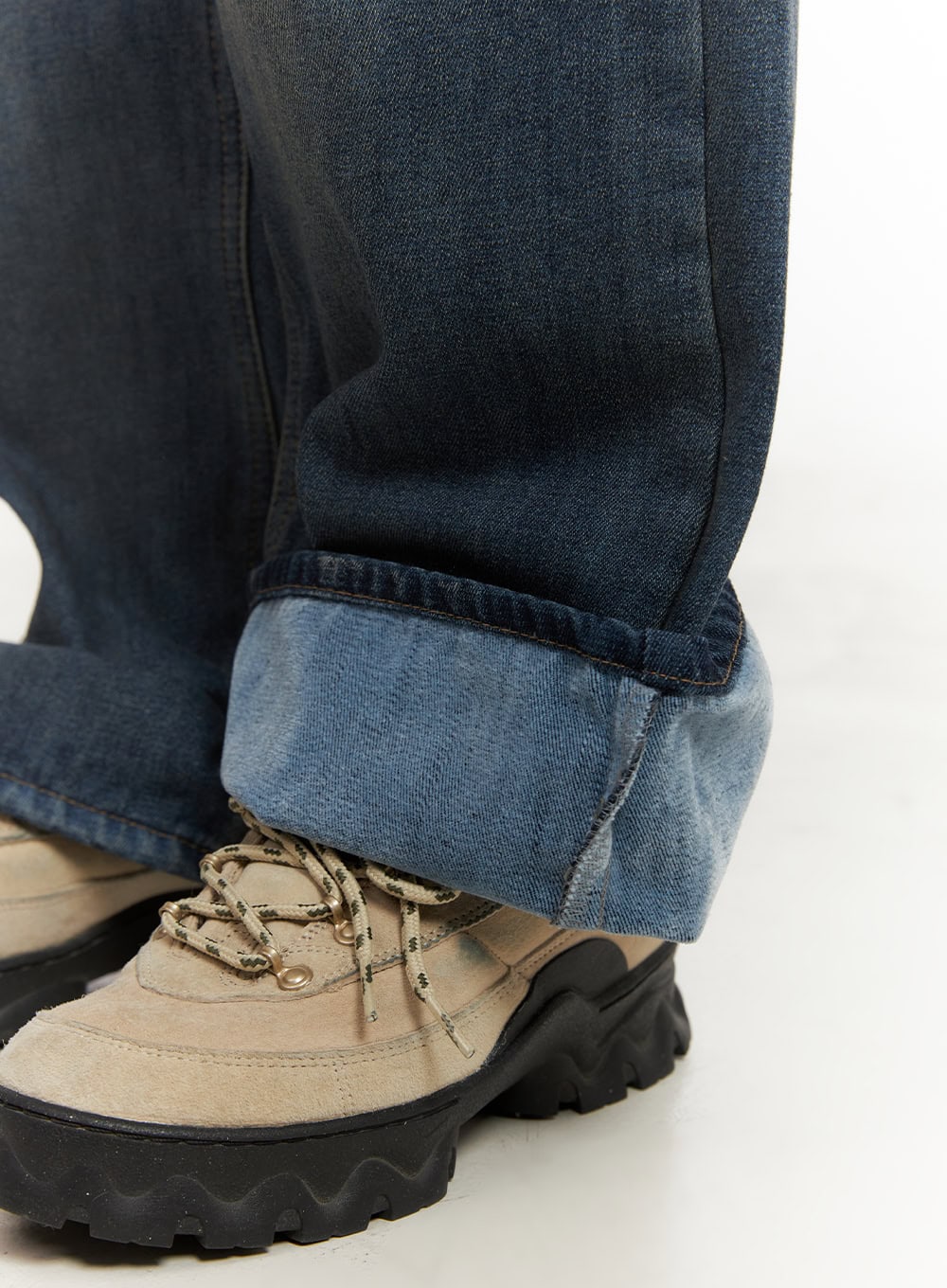 Michelle Washed Wide-Leg Jeans CJ508 in blue, close-up of hem and ankle on model, extra-long wide leg pooling over chunky lace-up boots with lighter inner denim visible at cuff.