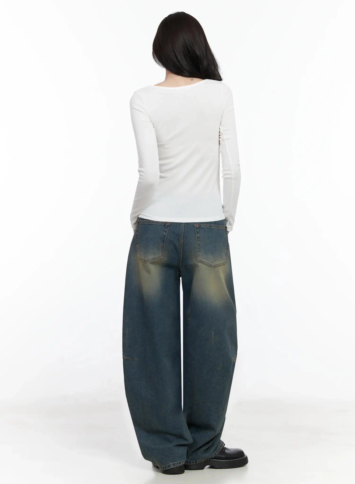 Tata Vintage Dark Blue Washed Wide Leg Jeans IJ528 in dark blue, back full-length shot on model, voluminous wide leg with back patch pockets, vintage yellow fade across seat and thigh, paired with white long-sleeve top and black loafers.