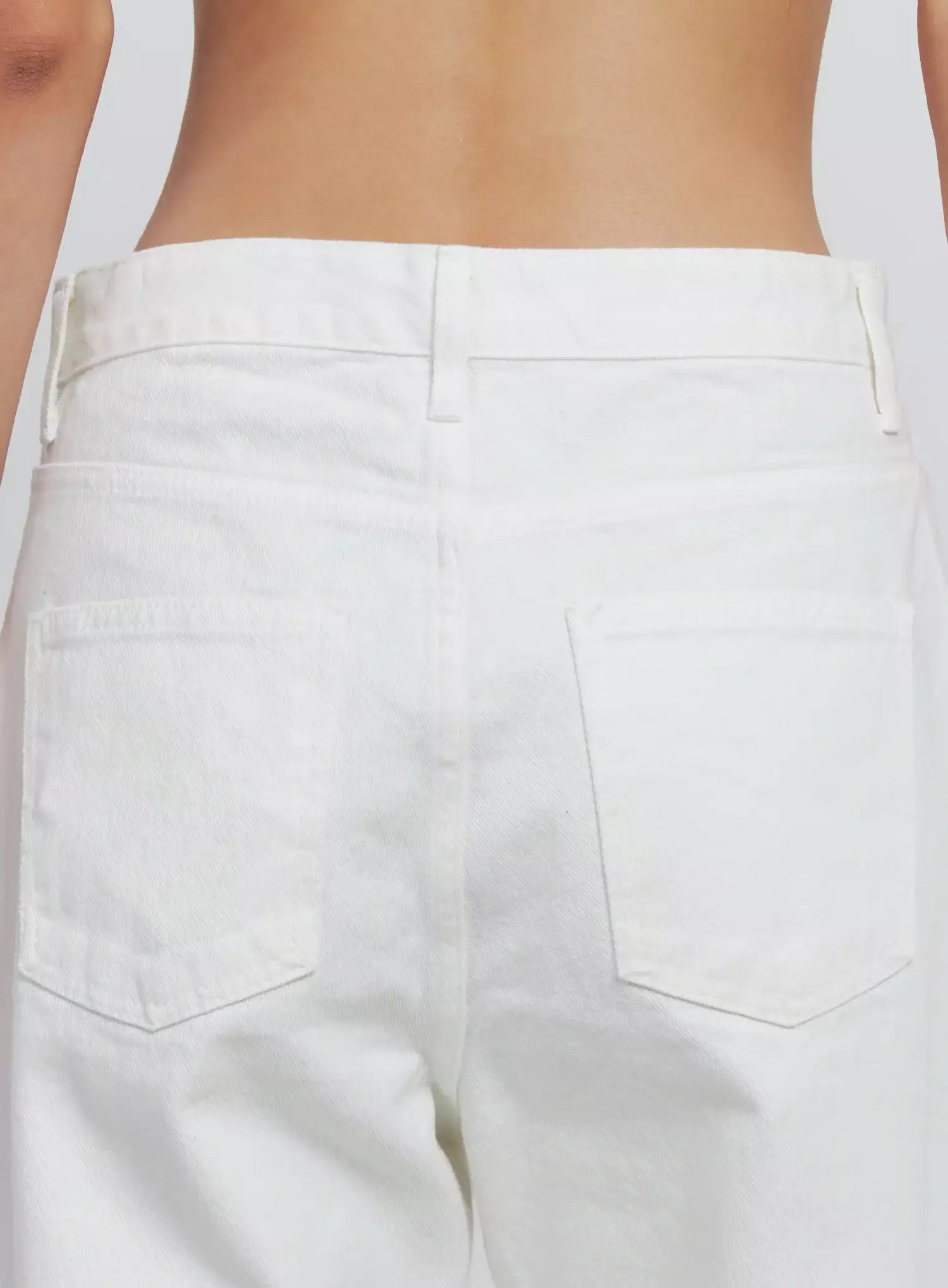 Taytum Straight-Leg Jeans IS515 in white, back waist close-up on model, detail of belt loops, back patch pockets, and denim texture visible.