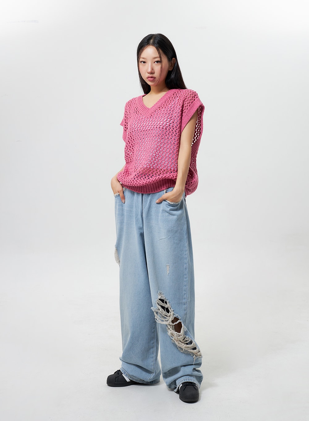 Oversized Ripped Jeans CY324 in light blue, full-body front on model with hands in pockets, wide-fit cotton denim, heavy ripped distressing on leg, casual oversized styling.