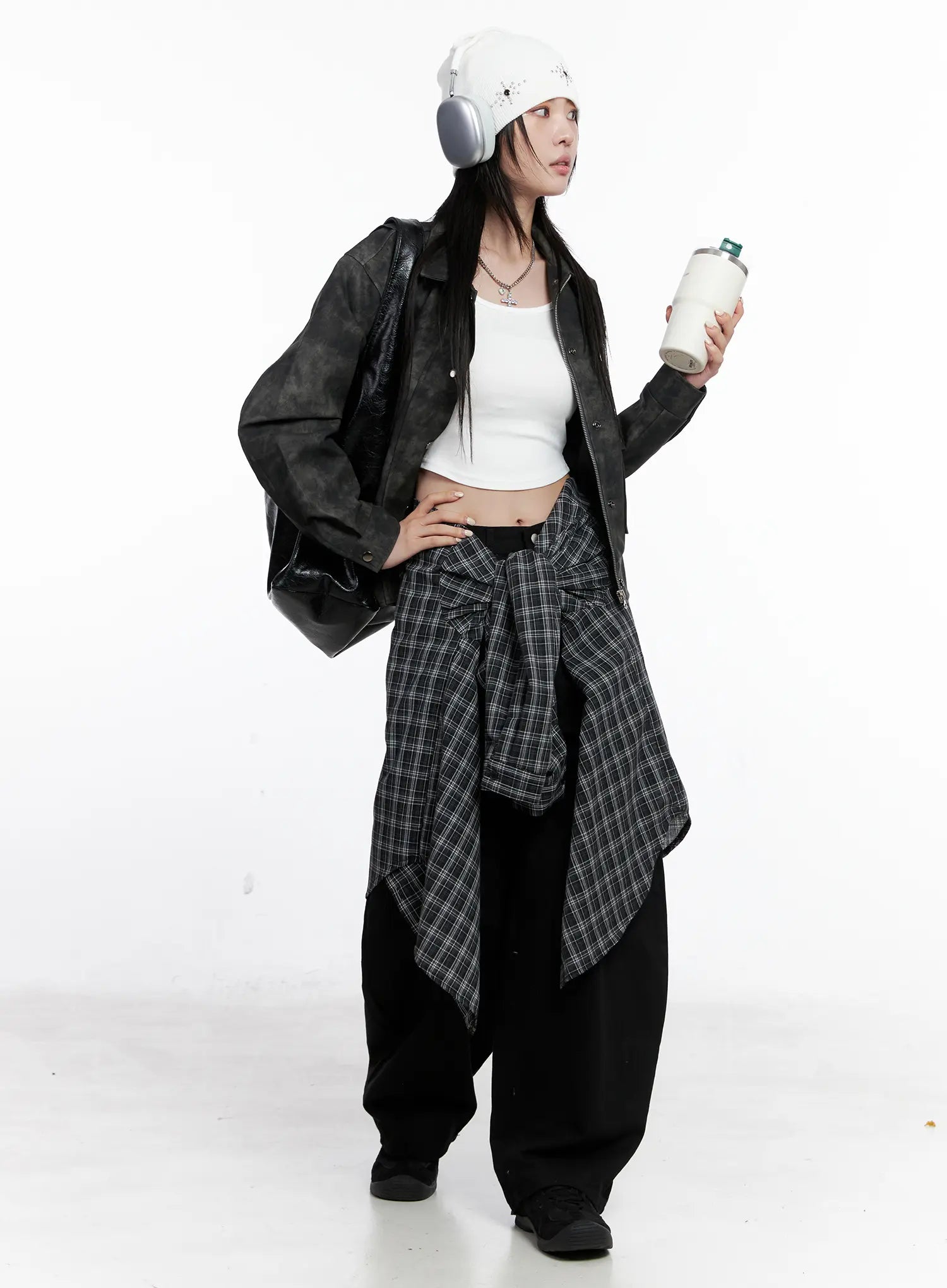 Nana Studded Belt Balloon Jeans CS512 in black, full outfit on model, layered with washed leather jacket, plaid shirt tied at waist, beanie and headphones, casual street styling.