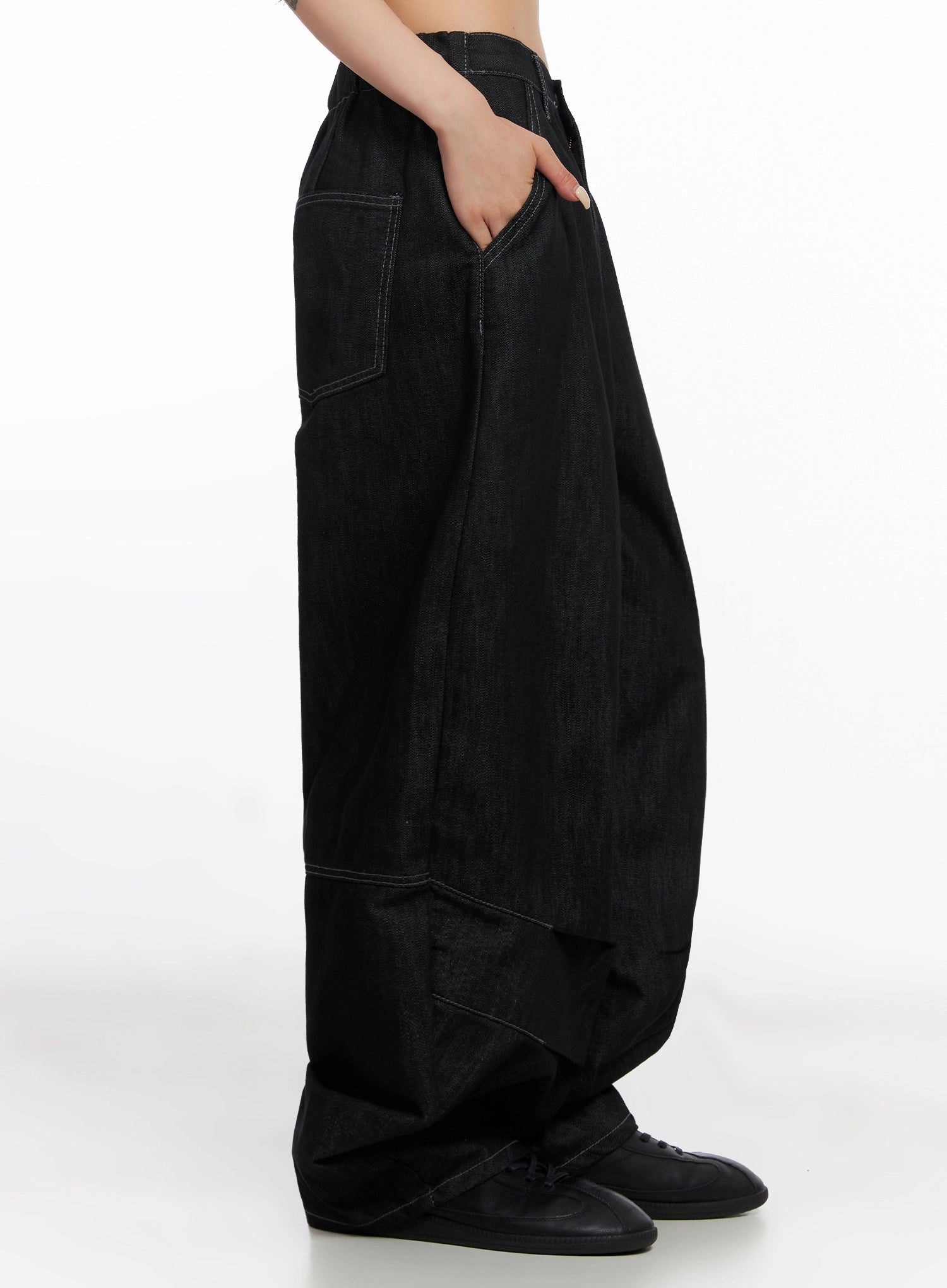 Leyla Pin-Tuck Wide-Leg Jeans IS515 in black, side close-up on model, hand in side pocket, pintuck panel seam and ballooned lower leg detail with contrast topstitching.