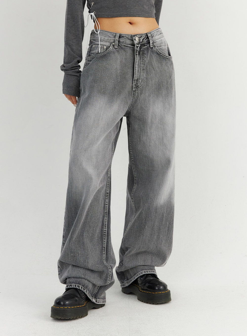 Grey Washed Wide Leg Jeans CO323 in Gray, front waist-down view on model, emphasizing the super-wide leg opening and faded denim wash with hem bunching over black chunky boots.