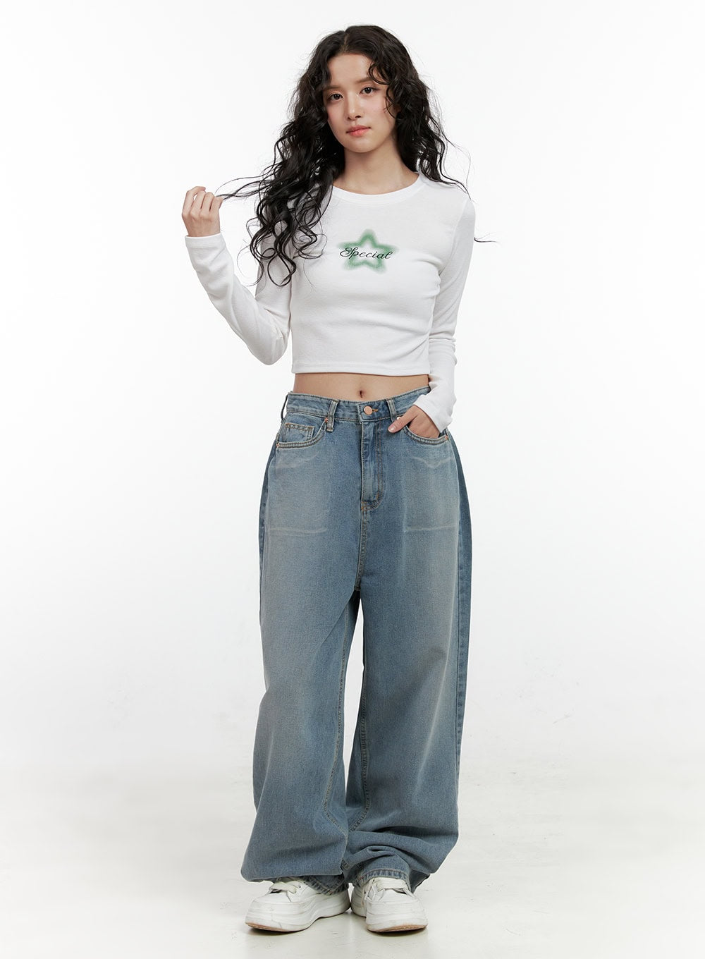 Taryn Chic Wide-Leg Jeans ON404 in light blue, full-body front shot on model, washed baggy denim with high waist, paired with white cropped long-sleeve graphic top and white sneakers.