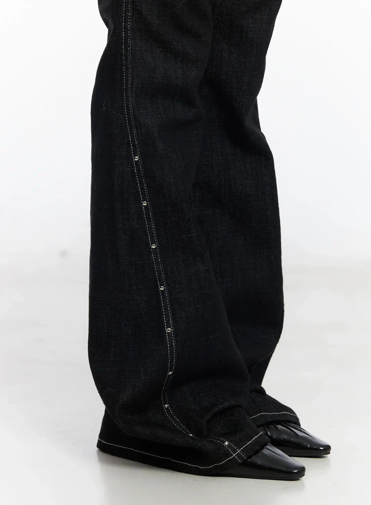 Dahy Stylish High-Waisted Bootcut Jeans CJ526 in black, close-up detail shot of side seam showing silver studs and contrast white stitching along the bootcut flare to hem.