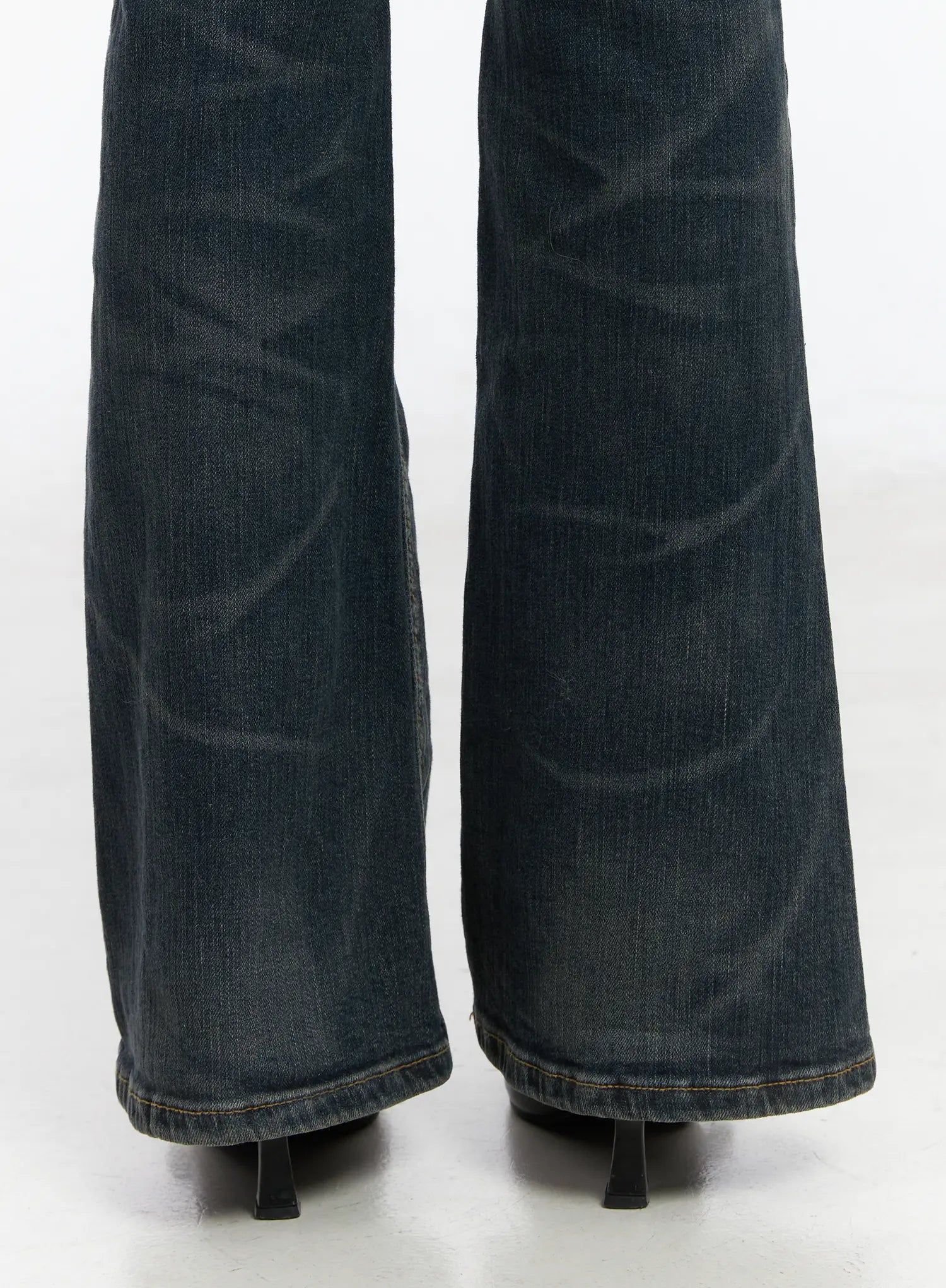 Kai Vintage Washed Flare Jeans CD515 in dark indigo, close-up of flared hem on model, showing bootcut flare width, whisker wash texture, and gold contrast hem stitching.
