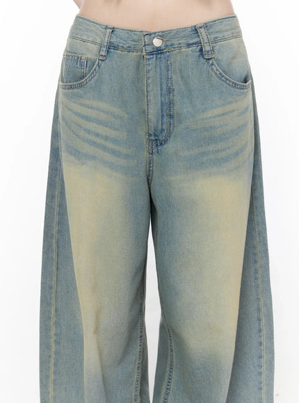 Rain Vintage Washed Wide Leg Jeans CU519 in light blue, close-up front detail on model, waistband with button closure, front pockets, and yellow sun-faded vintage wash whisker detailing.