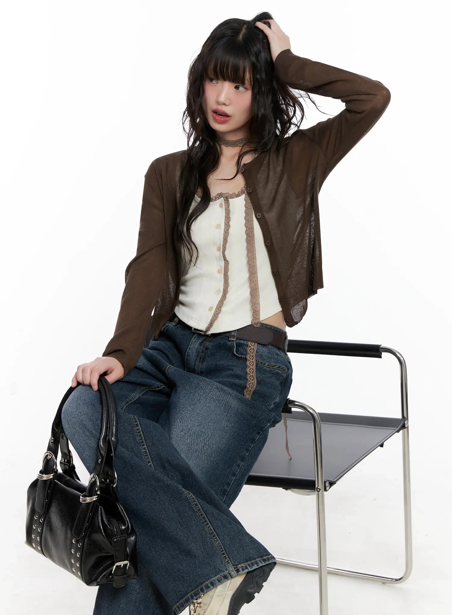 Mashiro Vintage-Wash Wide Jeans IL531 in dark blue, editorial sitting pose on model leaning on chair, wide-leg denim with belt, paired with brown sheer cardigan, white cami, and black studded bag.