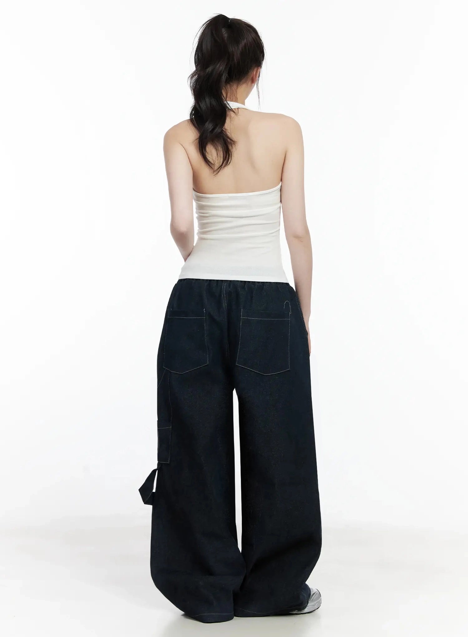 Ashlyn Carpenter Wide-Leg Jeans IJ528 in dark blue, back full-length view on model, two rear patch pockets with contrast stitching, elastic waistband, wide-leg hem pooling over sneakers.