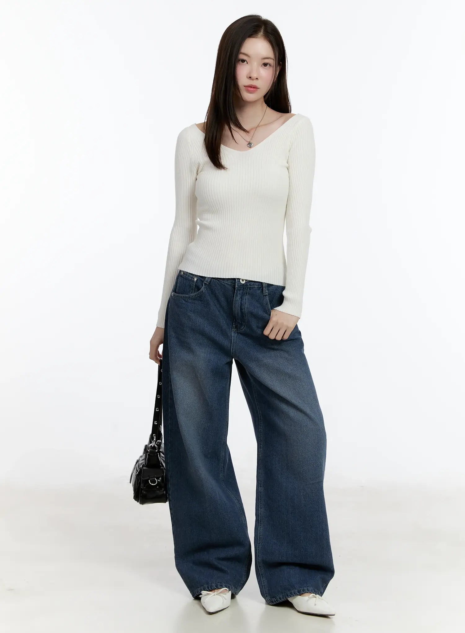 Della Casual Denim Wide Jeans ID511 in blue, full-body front shot on model, washed wide-fit cotton denim, long length, styled with cream ribbed V-neck knit and black mini bag accessory.