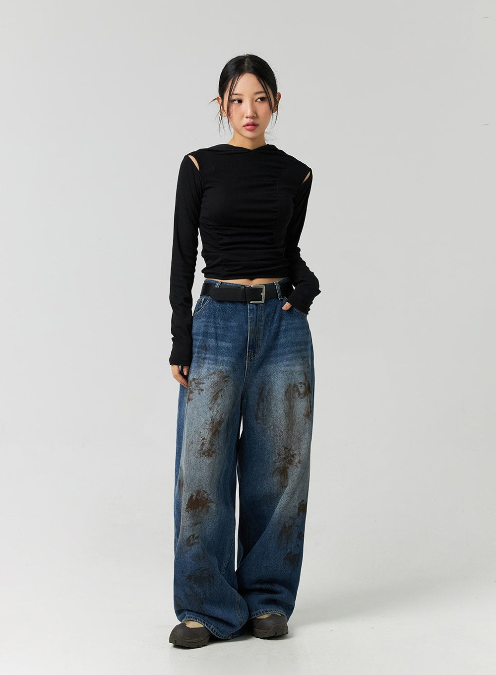 Street-Style Wide Fit Washed Jeans CO323 in Blue, full-body front on model with black cut-out crop top, relaxed wide leg cotton denim with brown washed pattern and black buckle belt.