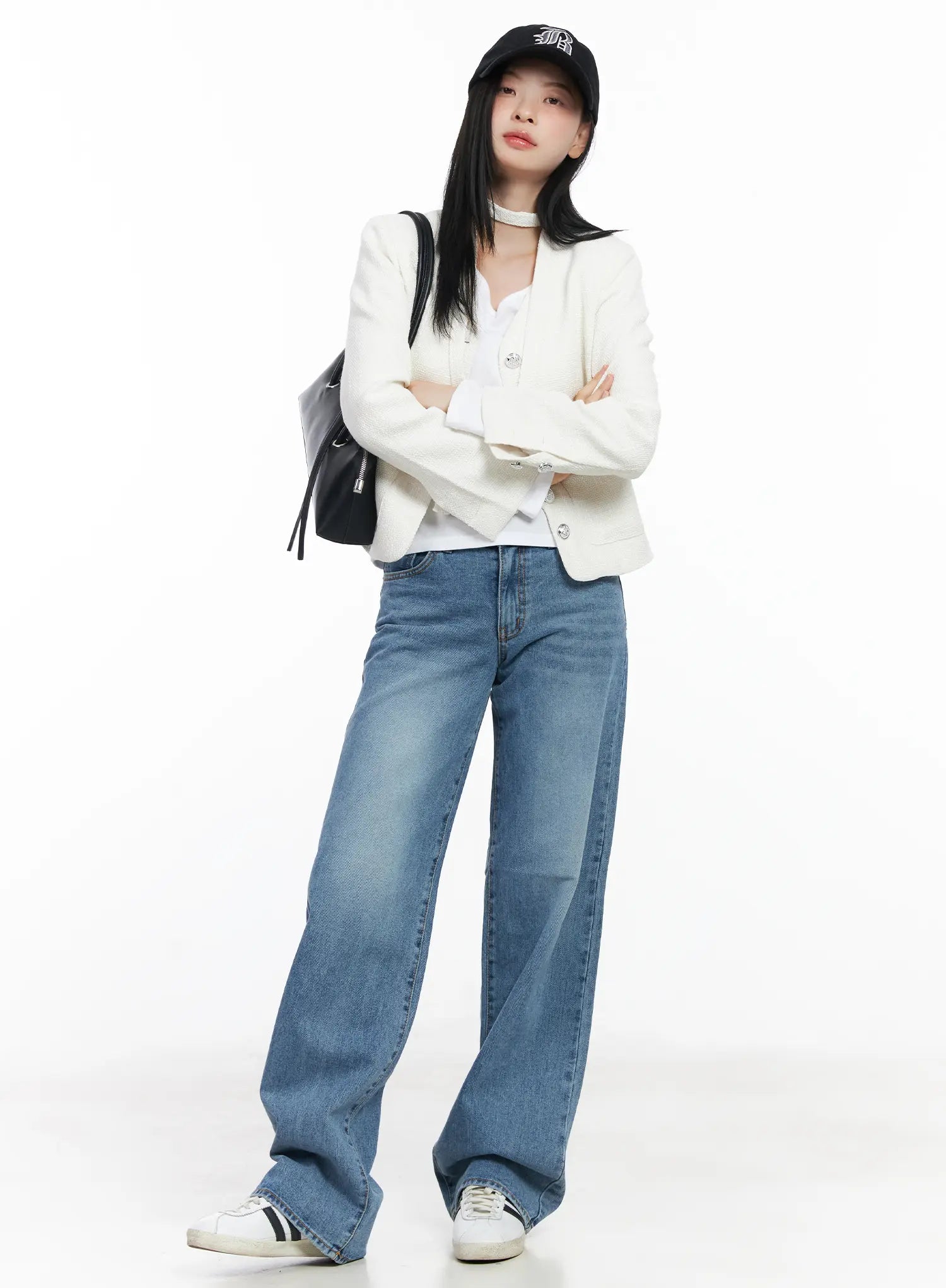 Maisy Casual Wide Leg Jeans CJ519 in blue, full-body outfit shot on model with arms crossed, styled with cream tweed jacket, white top, black cap and backpack, sneakers.
